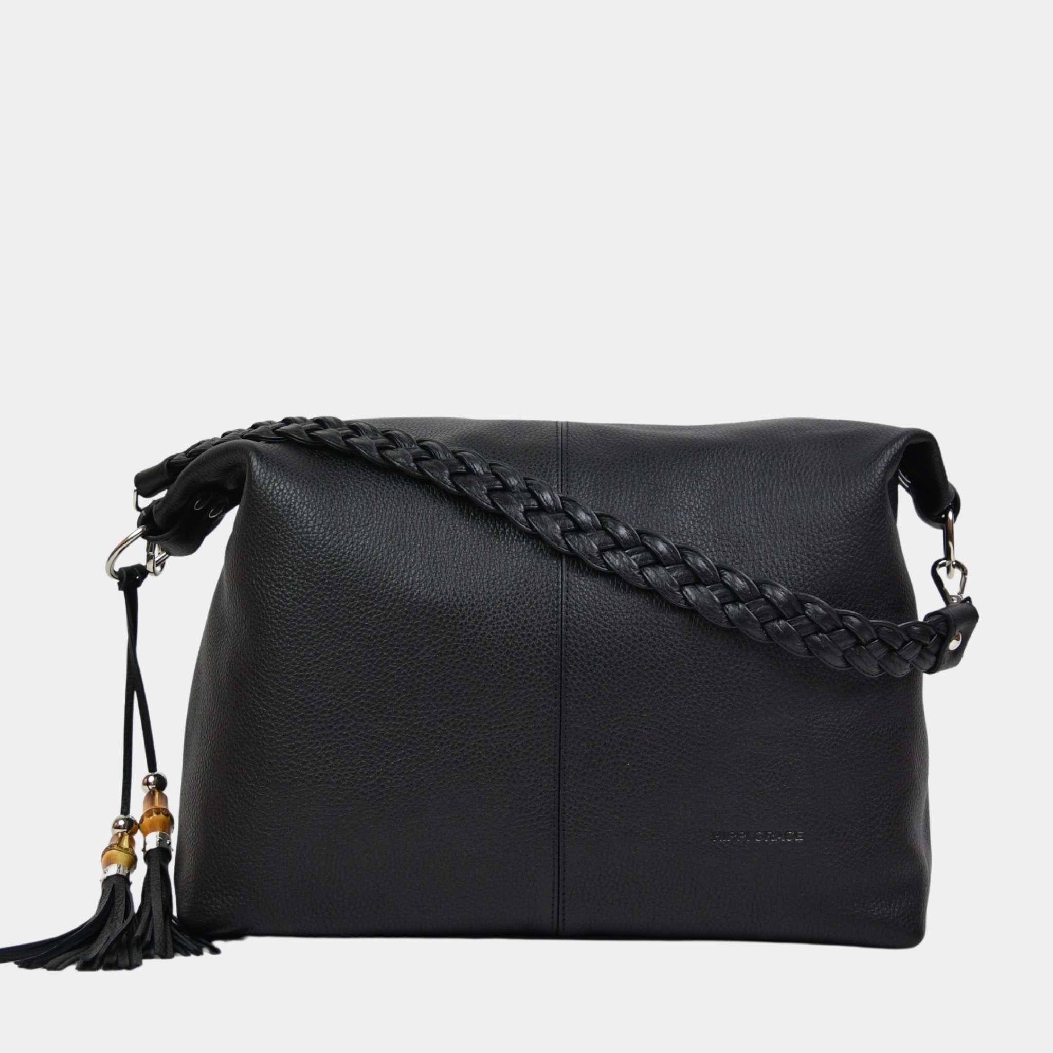 Romslig hverdags-veske i sort Ku skinn som kommer med flettet skulderreim, en crossbody stropp, glidelås-lukning og skinn-frynse detaljer. Vesken har også flere lommer innvendig.