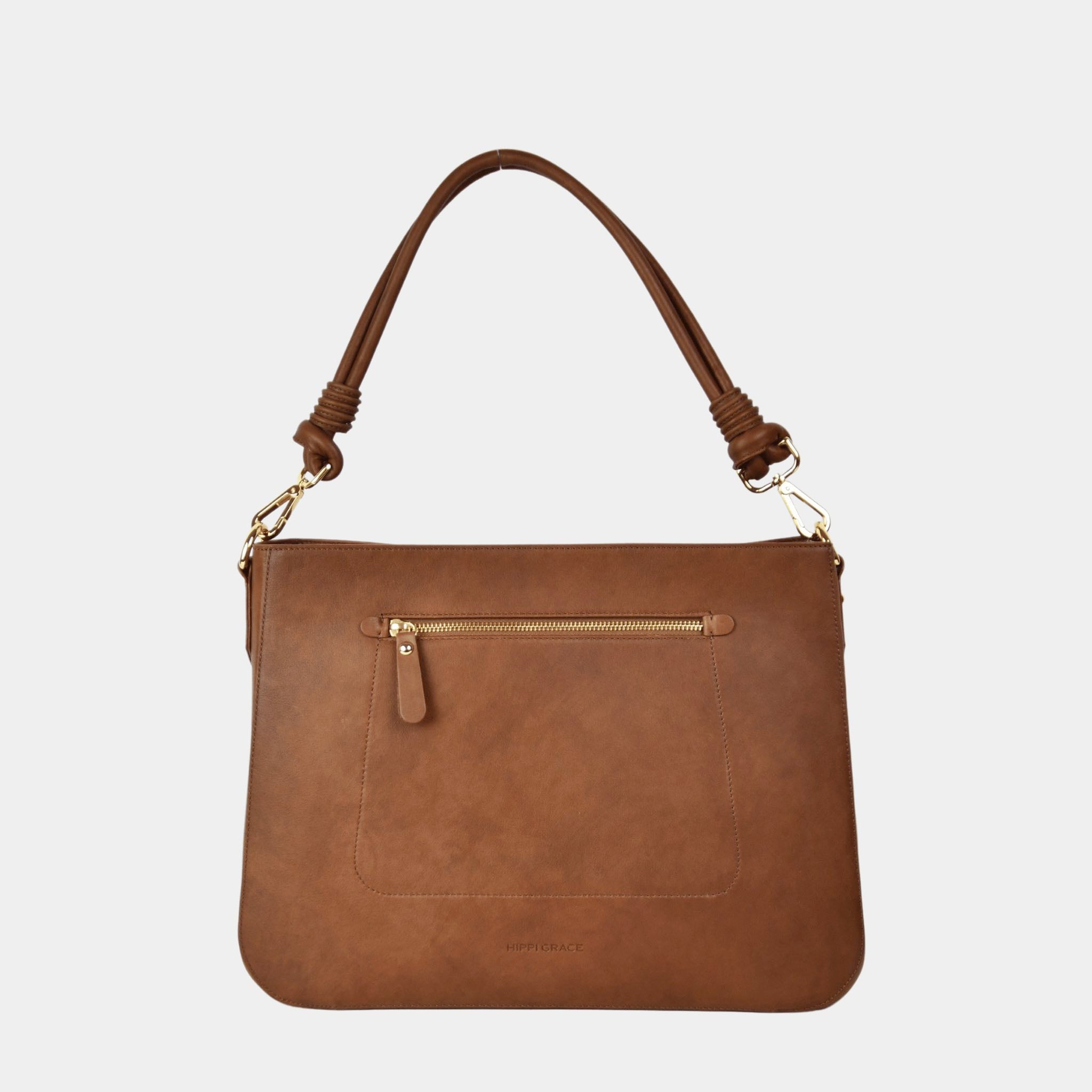 Jobbveske, Klassisk Ku-skinn, Skulderstropp, Crossbody stropp, Glidelås-lomme på framsiden, Glidelås-lukning. Hippi Grace Hamption i Bohem Luxe Tan med Gulldetaljer er en stor veske til dame i ekte skinn. Skinnvesken kommer med en skulderstropp og en regulerbar crossbody stropp. Den har er romslig og praktisk interiør med flere lommer innvendig, og glidelås lukking i topp. Hampton har et tidløst og praktisk design, som du aldri går lei av. Den er perfekt til Jobb, skole, reise og hverdag.
