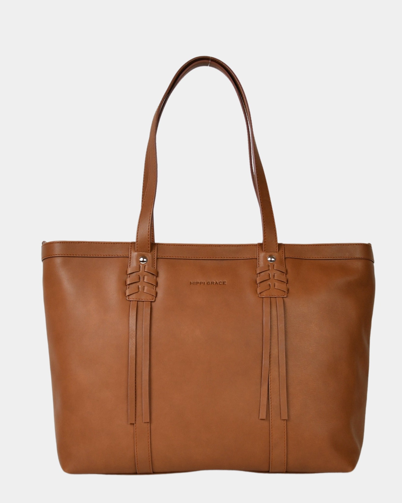 Hippi Grace Ibiza i fargen bohem luxe tan er en stor tote veske til dame i ekte skinn. Den har et praktisk og romslig interiør med flere lommer og glidelås lukking i topp. Den har pene frynse detaljer i front, og lange skulderremmer. Ibiza har et unikt og tidløst design du aldri går lei av. Skinnvesken er perfekt til jobb, skole, reise og hverdag. Norsk design. Stor veske dame. Stor Skulderveske i ekte skinn. Tote bag