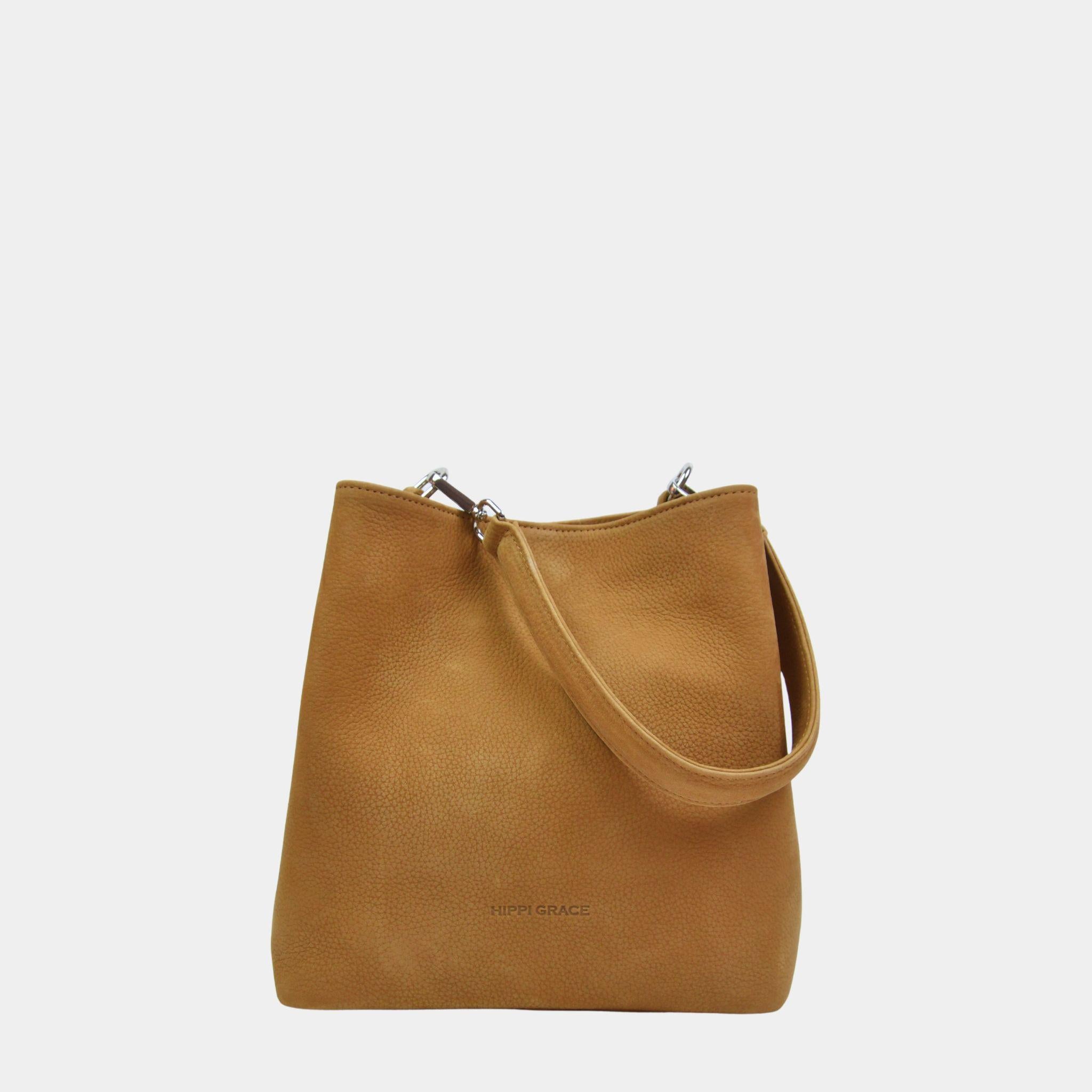 Skulderveske, Ku-skinn, Crossbody Stropp, Magnet lås, glidelås-lomme på framsiden, gulldetaljer. Hippi Grace Marbella i nobuck tan med gulldetaljer er en mellomstor skinnveske til dame. Vesken kommer med en skulderstropp og en regulerbar crossbody stropp, begge avtagbare. Vesken har et rent og elegant design, med et praktisk interiør. Veskens interiør har to hovedrom og lfere små lommer, med magnet lukking i topp. Lysebrun skulderveske dame. Lysebrun Crossbody veske. Brun skinnveske. Norsk design.