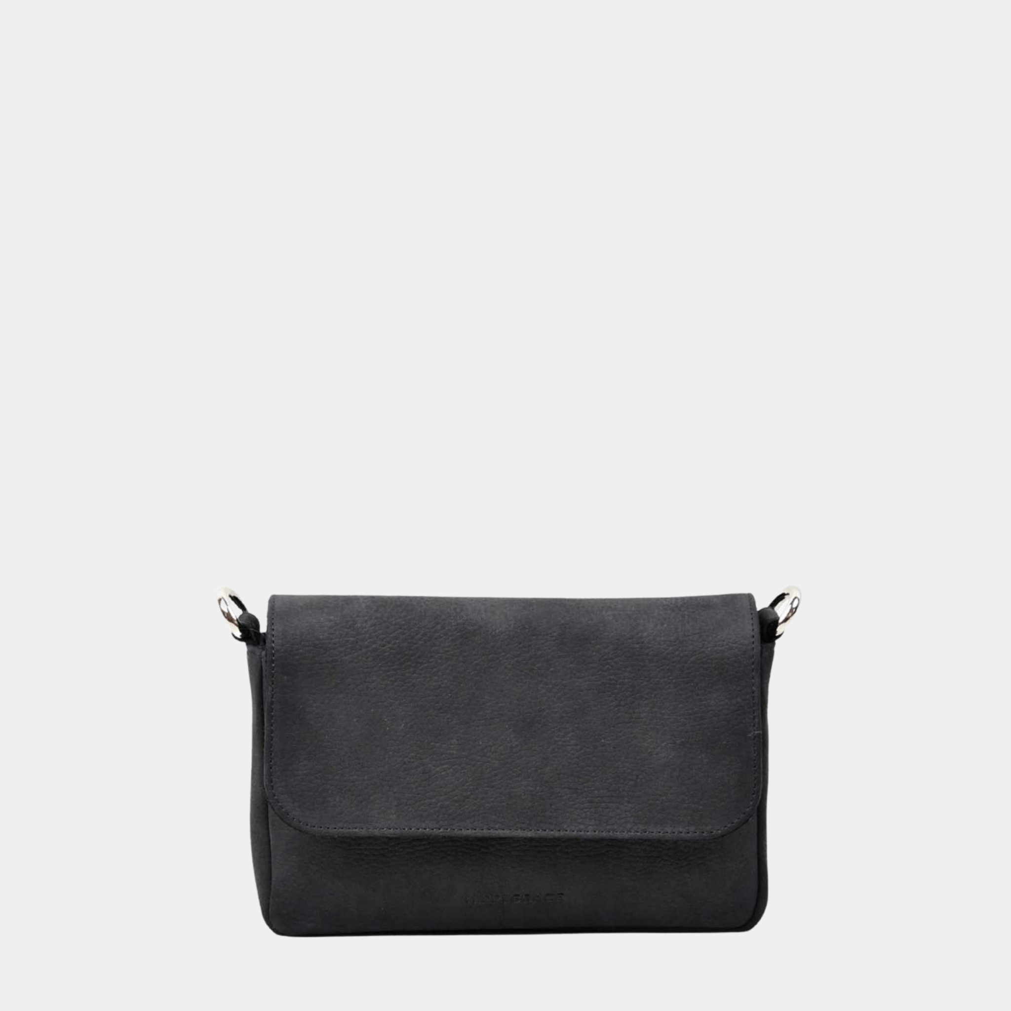 Liten veske, nobuck-skinn, magnet-lås, crossbody skulderstropp, sølvdetaljer. Hippi Grace Monte Carlo i fargen nobuck sort er en liten skinnveske til dame. Vesken kommer med en regulerbar crossbody stropp, avtagbar. Vesken har et stilrent og praktisk design, med magnet lås i front. Svart Crossbody veske i ekte skinn. Svart veske dame. Skulderveske svart. Norsk design. Bilde av baksiden til vesken.