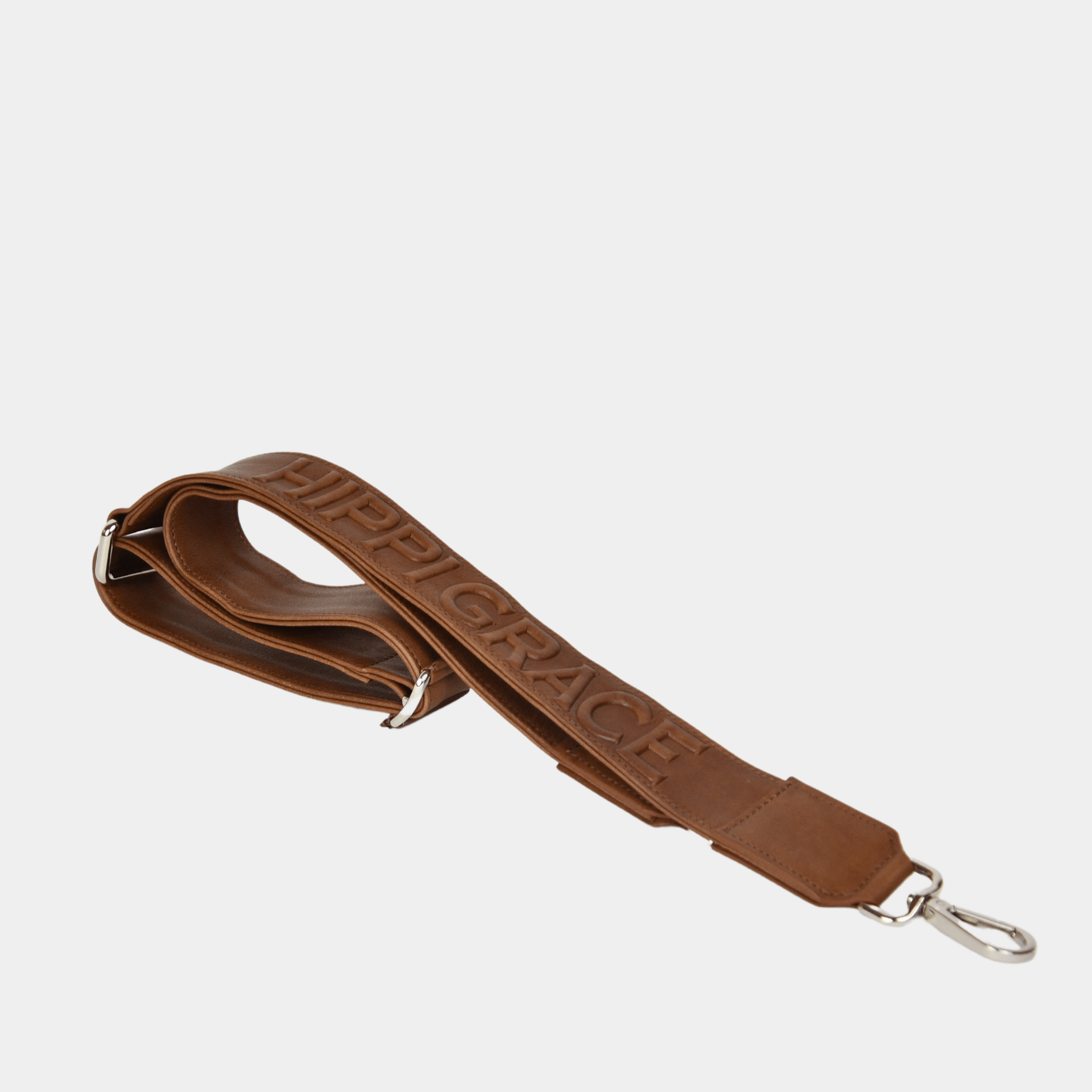 Bred skulderstropp i klassisk Ku-skinn, Crossbody lengde, Preget Logo, sølv detaljer. Hippi Grace Preget Regulerbar Stropp i Bohem Luxe Tan. Ekte skinn. Skinnstropp til veske i ekte skinn. Norsk Design.