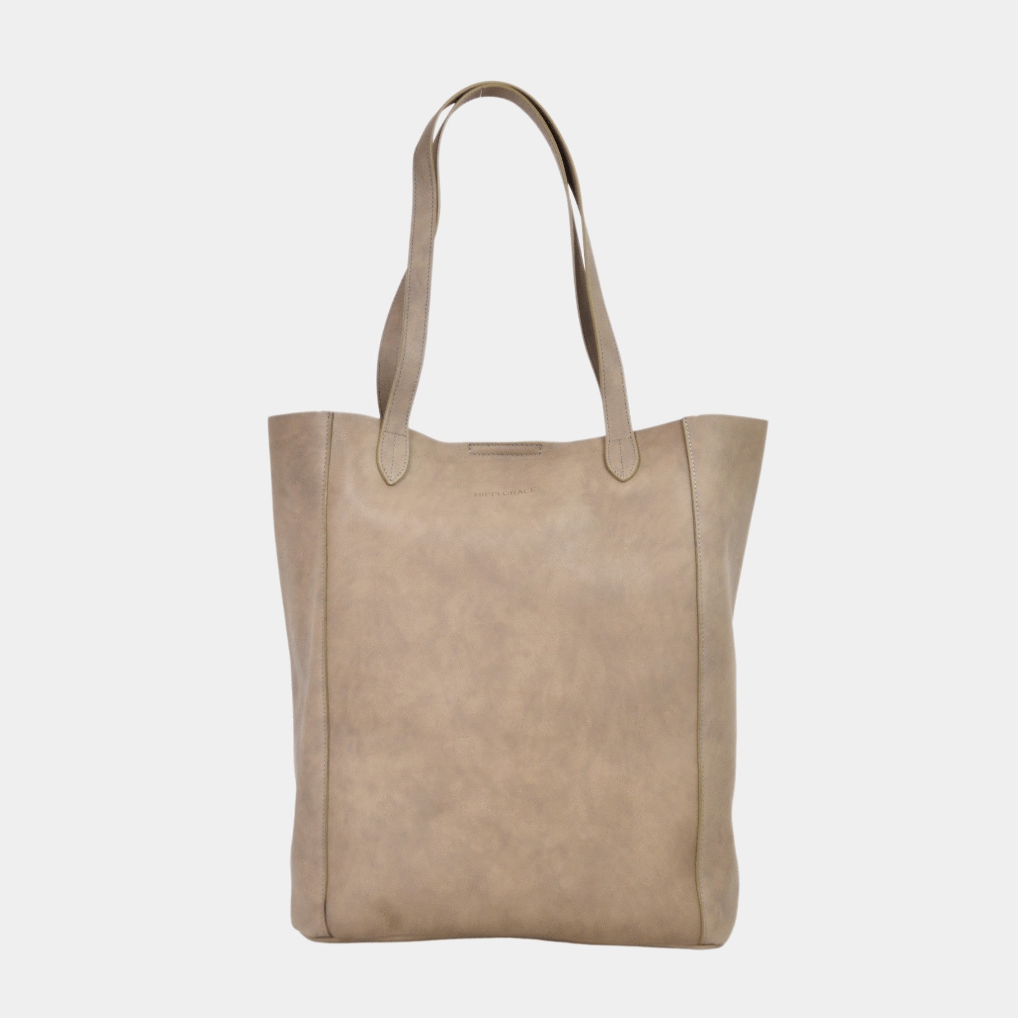 Tote veske i lekkert lyse brunt skinn fra Hippi Grace. Tote vesken Stockholm i fargen bohem luxe beige fra Hippi Grace er en stor skinnveske til dame. Skulder vesken passer perfekt som jobbveske, skoleveske, reiseveske og hverdagsveske. Vesken har et stilrent design, med et romslig interiør. Vesken lukkes med en metallknapp i topp. Skinnveske dame. Beige tote bag i ekte skinn. Beige skulderveske i ekte skinn. Norsk design.