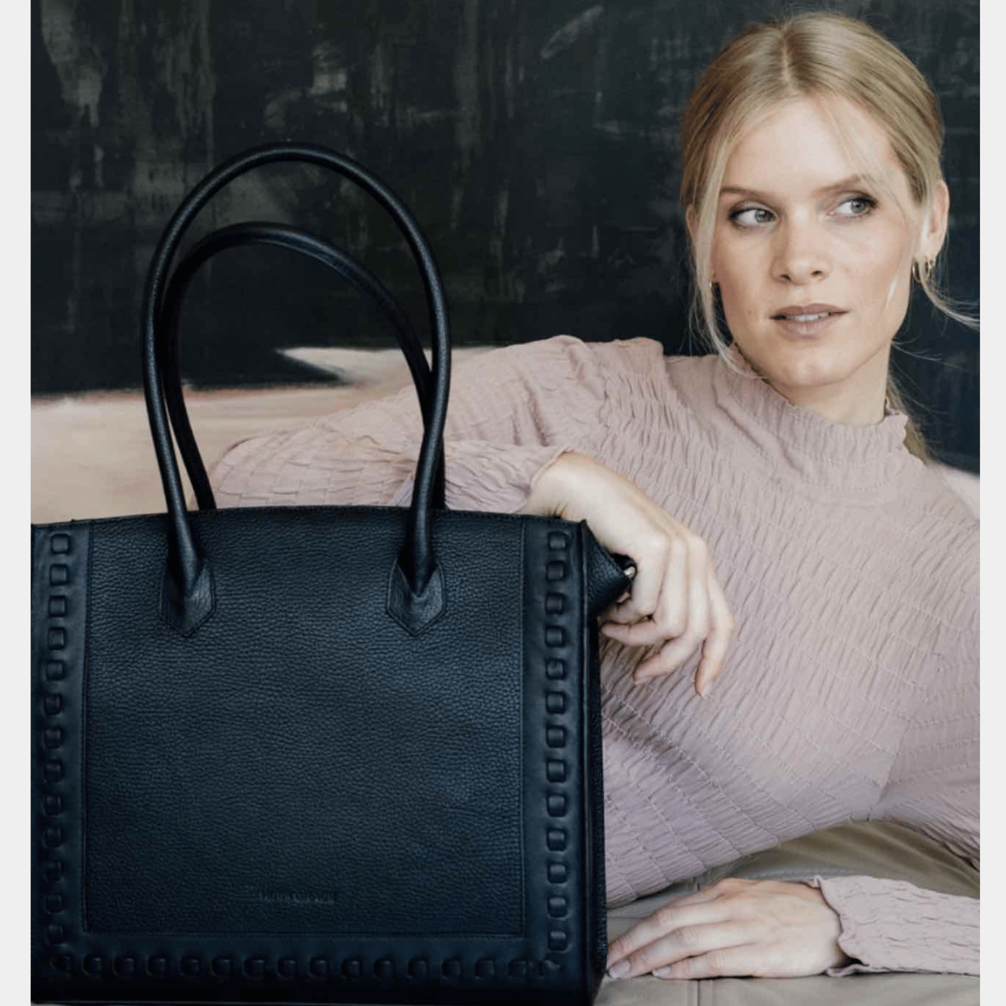 jobbveske, dame i ekte skinn i fargen sort. Hippi Grace Tromsø i fargen klassisk sort er en stor skulderveske til dame i ekte skinn. Vesken har et elegant design og et praktisk interiør, med glidelås lukking i topp. Skinnvesken kommer med skulderstropper og en regulerbar crossbody stropp som er avtagbar. Jobbveske svart. Jobbveske Skinn. Svart skinnveske dame. Svart Skulderveske i ekte skinn. Norsk design. Svart skoleveske dame. Svart reiseveske. Hverdagsveske svart. Bilde av Tromsø med modell.