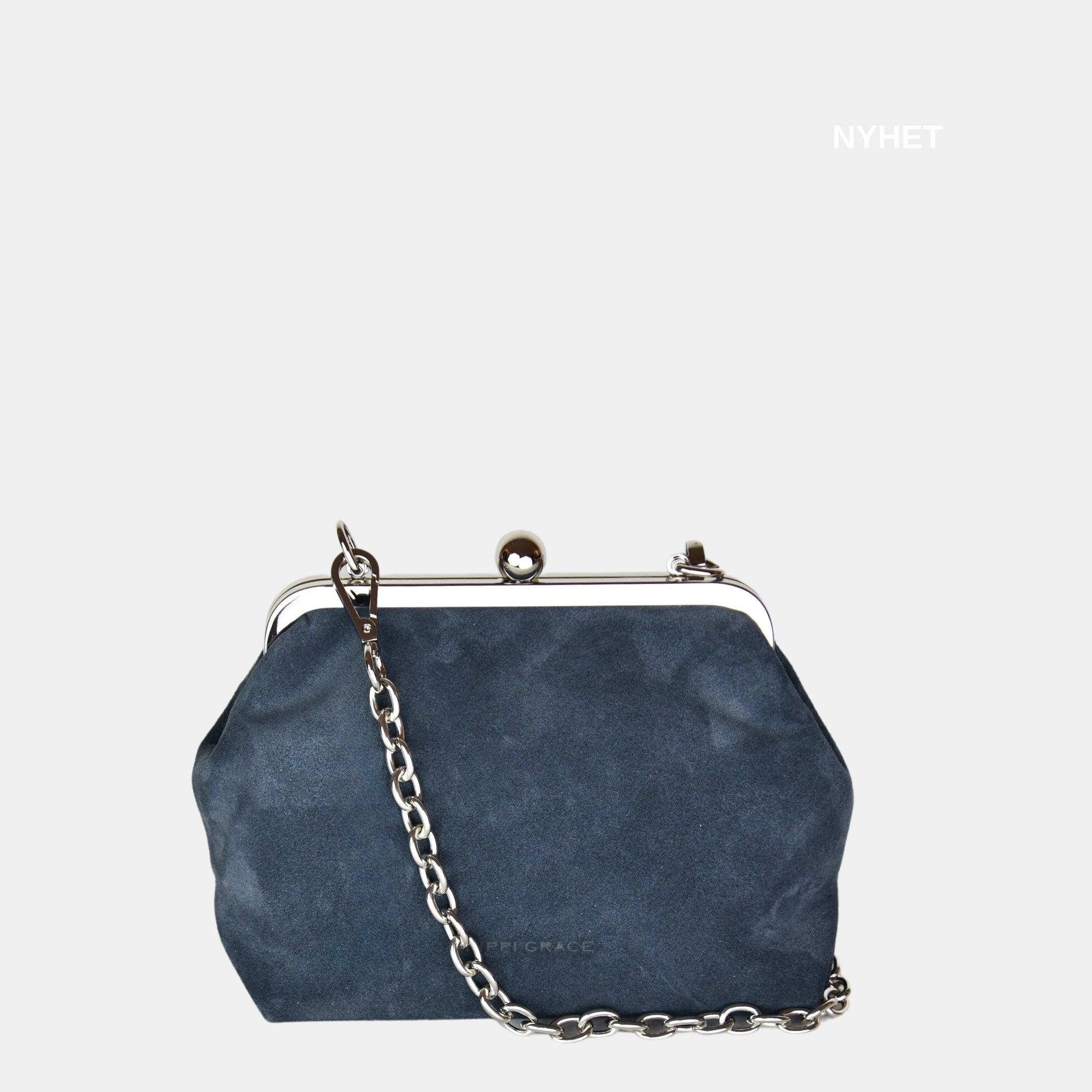 Hippi Grace Positano i fargen Suede Gråblå er en liten skinnveske til dame i Norsk Design. Vesken er laget av nydelig semsket skinn, og har lekre sølv detaljer og klikk lås i topp. Selskapsvesken kommer med en lekker metall chain som stropp og en regulerbar Crossbody Stropp, begge avtagbare. . Denne festvesken har et unikt design og et smart interiør. Et smykke til din garderobe. Gråblå veske i semsket skinn. Veske i suede. Gråblå Suede Veske Dame. Bilde av forsiden til Positano