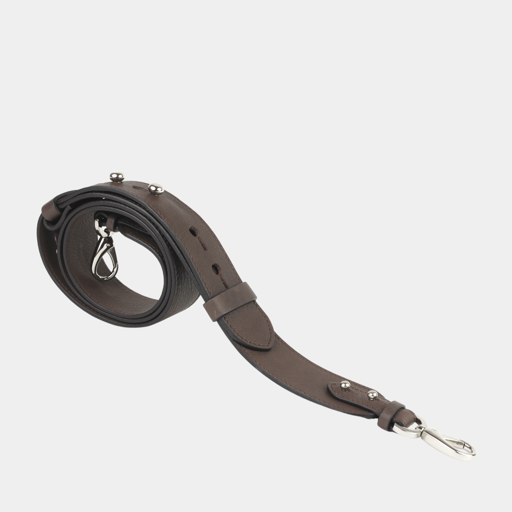 Skulderstropp, Klassisk Ku-skinn, crossbody lengde, regulerbare knapper, gull detaljer. Hippi Grace Crossbody stropp klassisk med studs i fargen Bohem Luxe Mocca med sølv. Mørkebrun skinnstropp med sølvdetaljer til veske. Tilbehør til veske. Norsk Design.