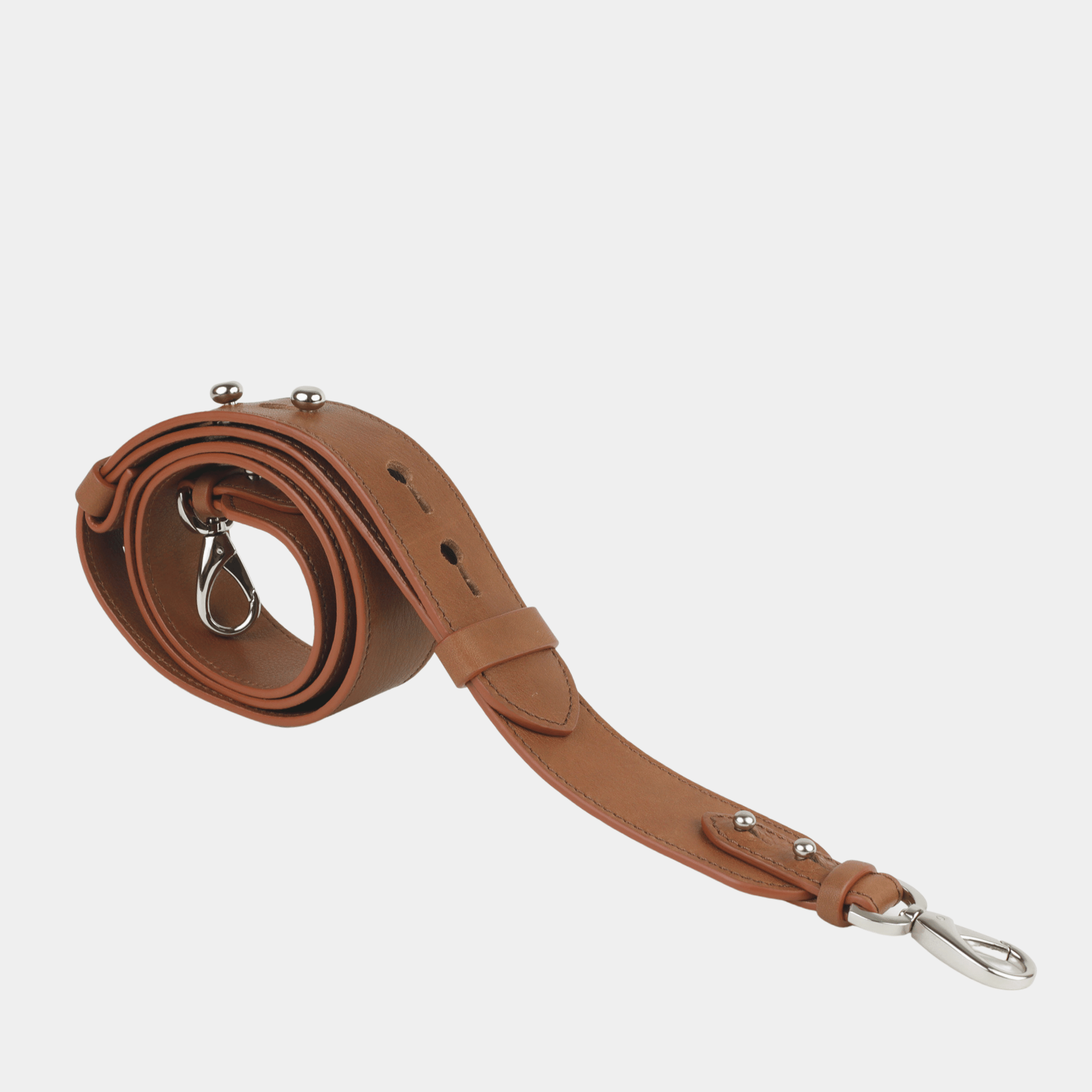 Skulderstropp, Klassisk Ku-skinn, crossbody lengde, regulerbare knapper, gull detaljer. Hippi Grace Crossbody stropp klassisk med studs i fargen Bohem Luxe Tan med sølv. Brun skinnstropp med sølvdetaljer til veske. Tilbehør til veske. Norsk Design.