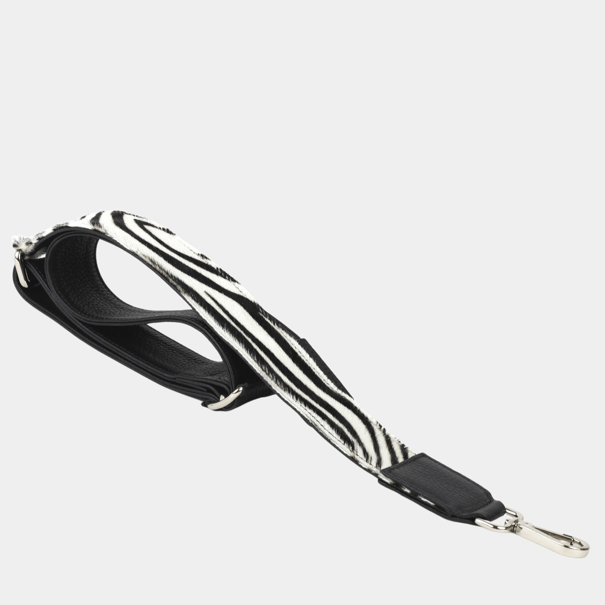 Bred skulderstropp i klassisk Ku-skinn, Crossbody lengde, Preget Logo, sølv detaljer. Hippi Grace Preget Regulerbar Stropp i Klassisk Sort med Zebra Print. Ekte skinn. Skinnstropp til veske i ekte skinn. Norsk Design.