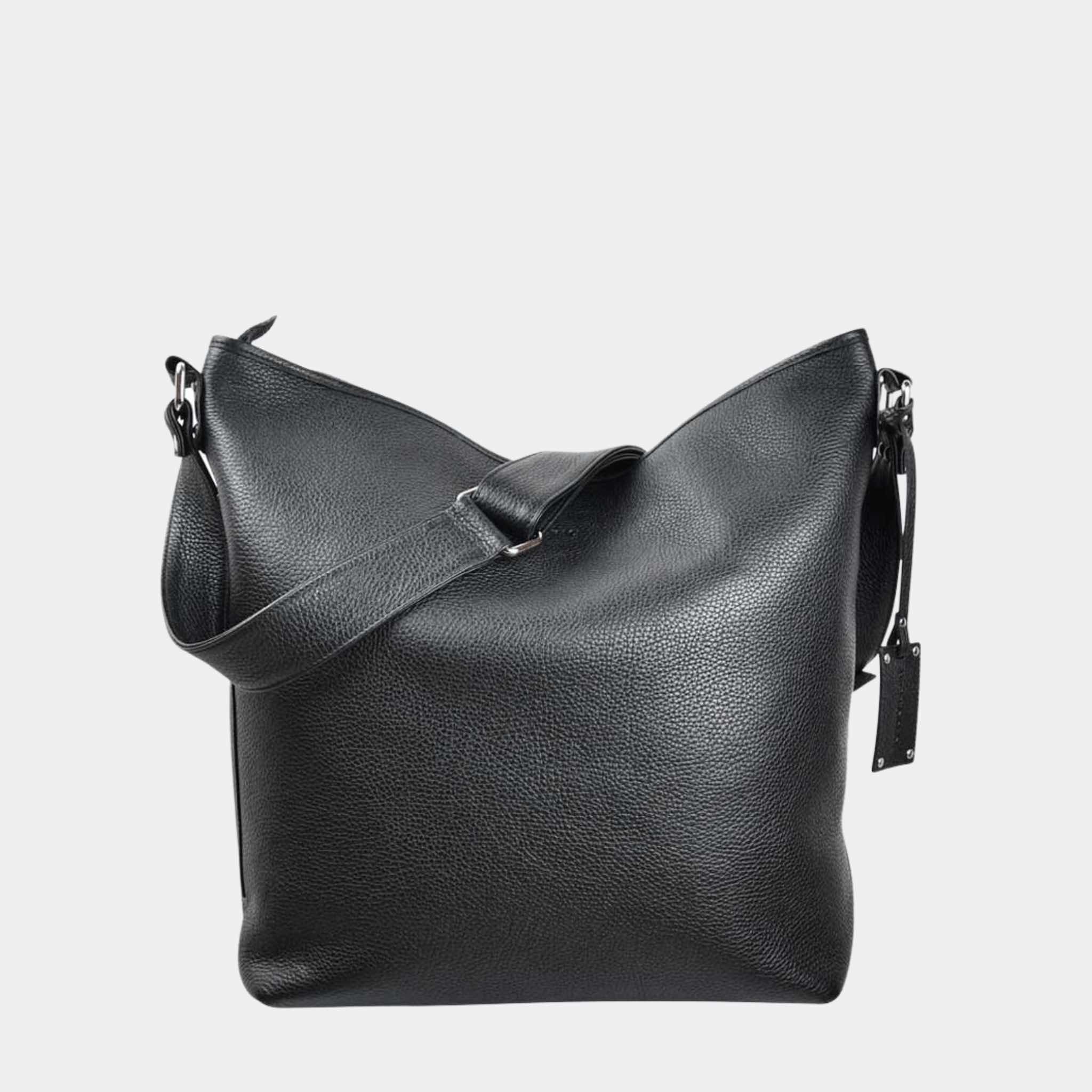 Romslig Crossbody veske fra Hippi Grace. Jobbveske dame. Skoleveske dame. Reiseveske dame. Hverdagsveske dame. PC veske dame. Sort veske til dame i ekte skinn. Svart veske til dame i ekte skinn.  Bag. Skinn Vekse. PC-veske dame. Norsk Design. Romslig veske i ekte skinn til dame. Hippi Grace Veske Amsterdam i fargen klassisk sort. Sort skinnveske til dame. Svart skinnveske til dame. Romslig skoleveske, glidelås-lukning og lang skulderreim. Sort Skinnveske i ekte skinn til dame.