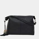 Romslig hverdags-veske i sort Ku skinn som kommer med flettet skulderreim, en crossbody stropp, glidelås-lukning og skinn-frynse detaljer. Vesken har også flere lommer innvendig.