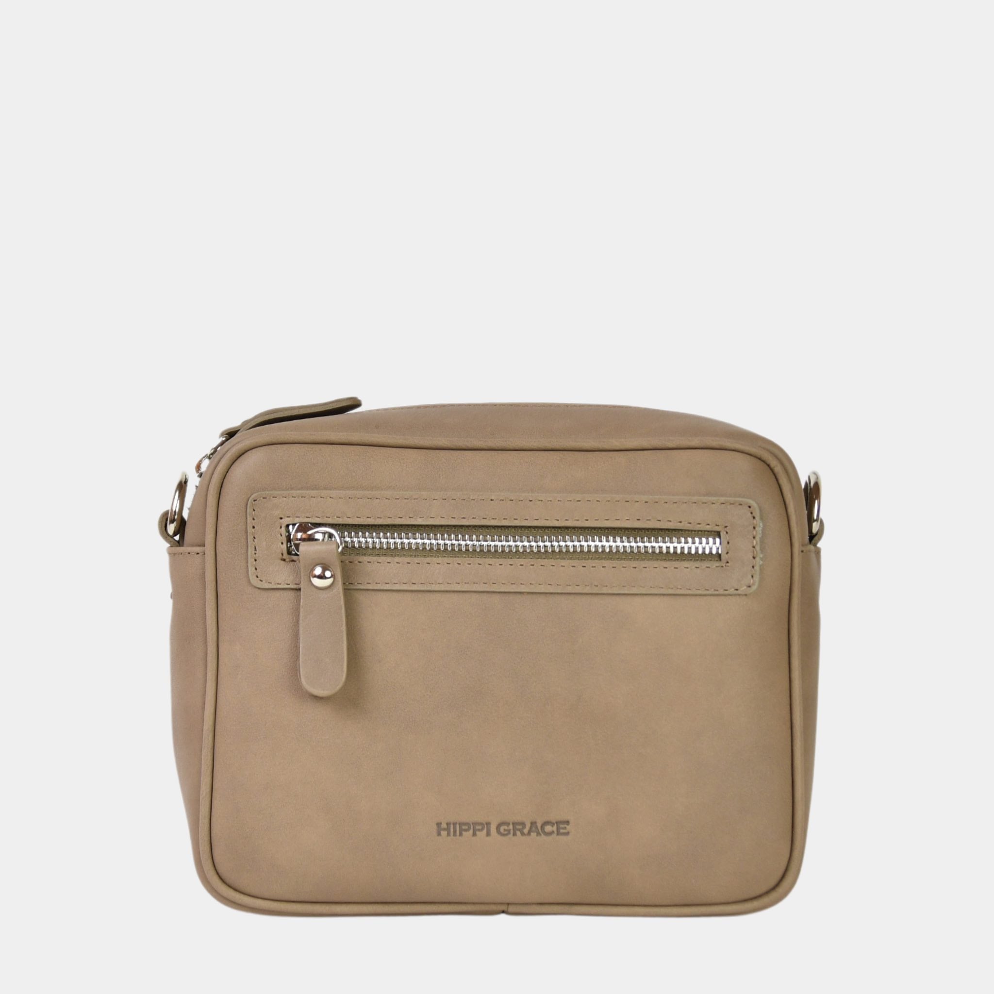 Hippi Grace Brighton er en liten veske til dame i ekte skinn. Vesken kommer med en regulerbar crossbody stropp. Vesken har et praktisk interiør med glidelås lukking i topp, samt en glidelås lomme på forsiden av vesken. Liten Skinnveske Til Dame. Lys beige Skinnveske til dame. Liten veske til dame i lys beige. Beige skinnveske. Liten Crossbody veske. Veske Dame. Brighton i fargen bohem luxe beige med sølv detaljer. Norsk Design.