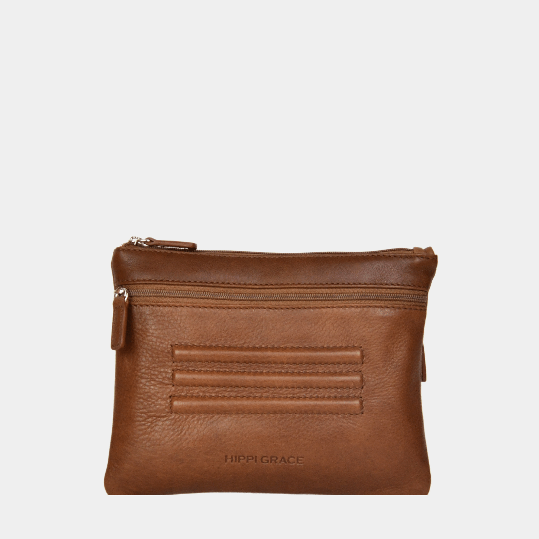 Hippi Grace Cadizfornia er en Liten veske  til dame i ekte skinn, crossbody skulderstropp, håndeddstropp,utvendig glidelås-lomme foran og bak, glidelås lukking, sølvdetaljer. Hippi Grace Cadizfornia i fargen Bohem Luxe Tan med sølv detaljer. Cognac veske. Brun Veske. Veske Dame. Norsk Design. Liten Crossbody veske dame. Vesken har et praktisk interiør og har glidelås lukking i topp. 