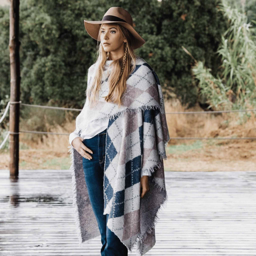 Wrap Poncho i alpakka fra Hippi Grace. Blå og Grå poncho til dame. Alpakka Ull til dame. Hippi Grace Klær. Wrap Poncho i fargen blå grå mix til dame laget i Alpakka ull. Hippi Grace Poncho. Norsk design. Sjal til dame i alpakka ull fra Hippi Grace i fargene Blå og grå. 