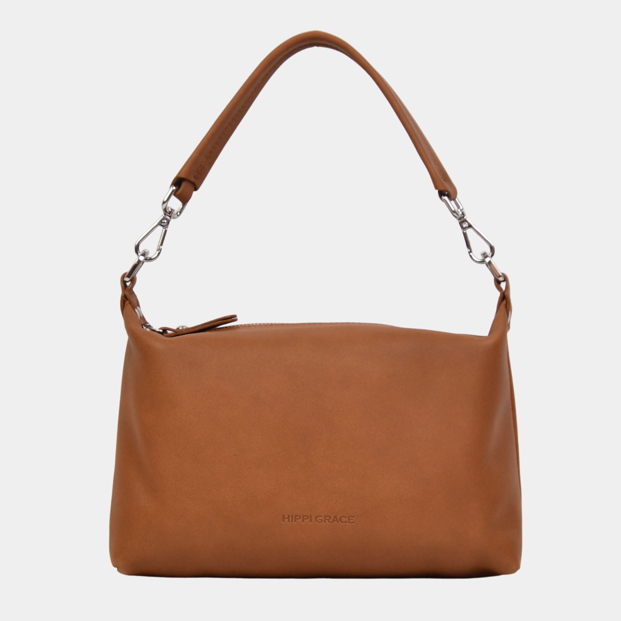 Hippi Grace Lucca i fargen bohem luxe tan er en liten skinnveske til dame. Vesken har et minimalistisk og tidløst design, og har et praktisk interiør med glidelås lukking i topp. Skinnvesken kommer med en skulderstropp og en regulerbar crossbody stropp, begge avtagnbare. Norsk Design. Lysebrun skinnveske dame. Brun Veske dame. Hverdagsveske. Festveske. Ekte skinn. Bærekraftig. Skulderveske dame. Crossbody veske dame. Crossbodyveske. Små veske. Mindre veske. Bilde av vesken foran. [wv]