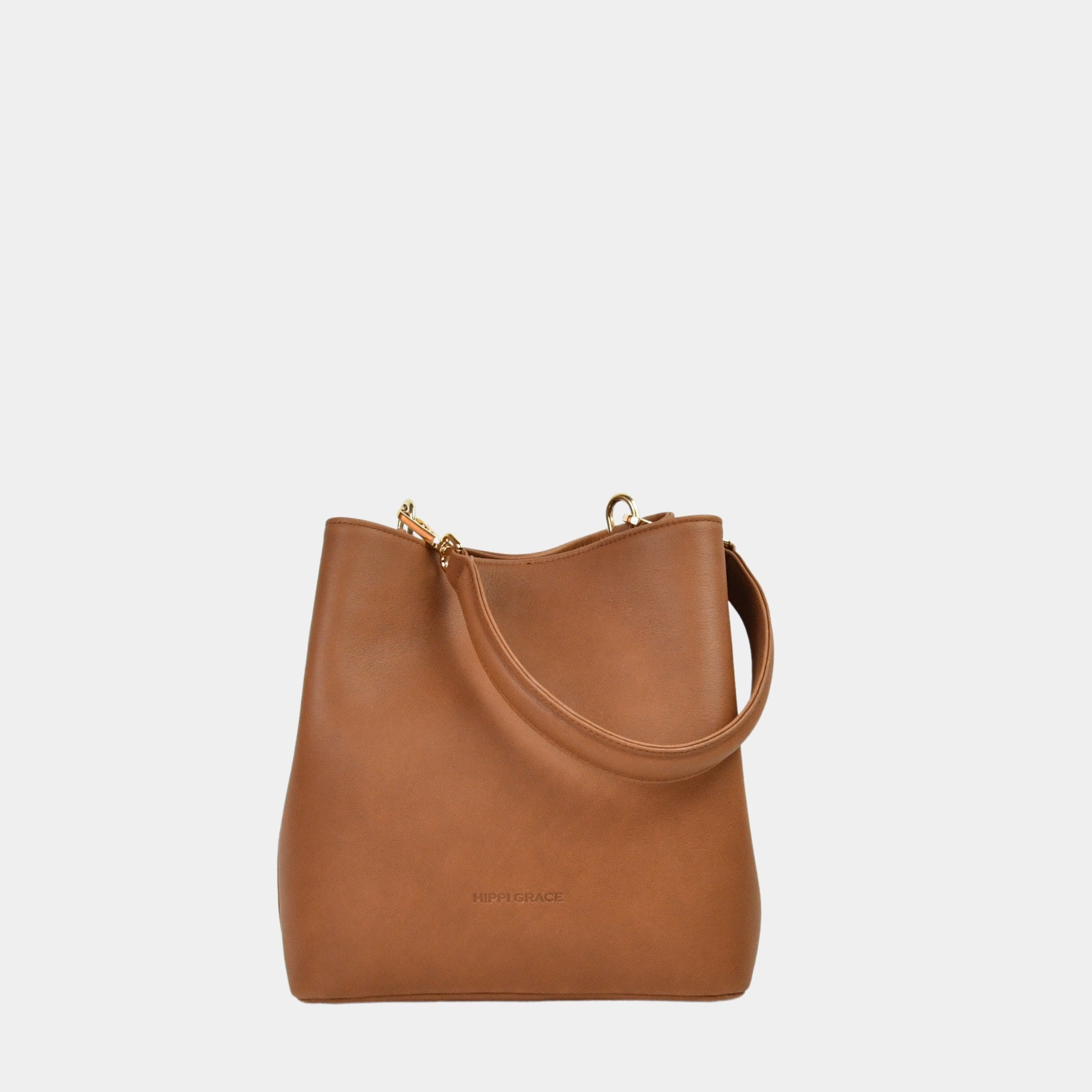 Hippi Grace Marbella i Bohem Luxe Tan med Gulldetaljer er en mellomstor skinnveske til dame. Vesken kommer med en skulderstropp og en regulerbar crossbody stropp, begge avtagbare. Vesken har et rent og elegant design, med et praktisk interiør. Veskens interiør har to hovedrom og flere små lommer, med magnet lukking i topp. Lysebrun skulderveske dame. Lysebrun Crossbody veske. Brun skinnveske. Norsk design. Bucket Bag i ekte skinn. 