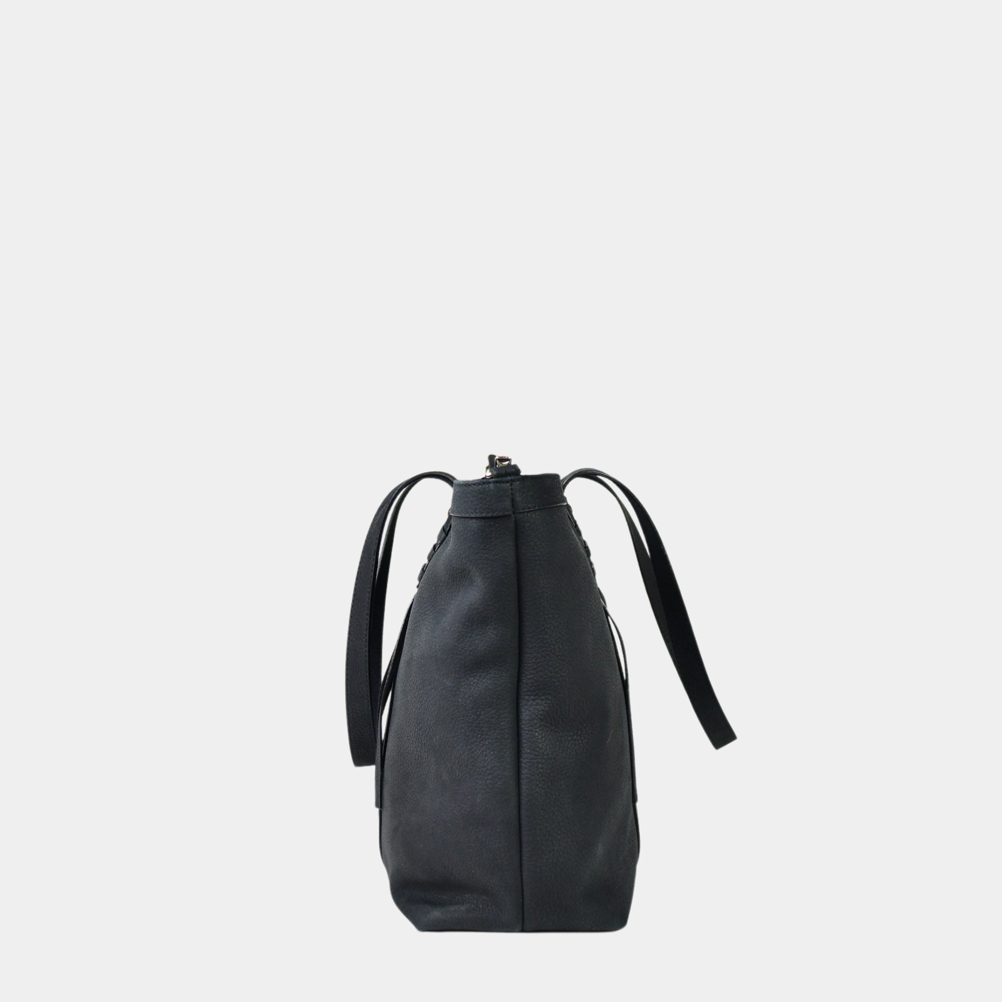 Hippi Grace Ibiza i fargen klassisk sort er en stor tote veske til dame i ekte skinn. Den har et praktisk og romslig interiør med flere lommer og glidelås lukking i topp. Den har pene frynse detaljer i front, og lange skulderremmer. Ibiza har et unikt og tidløst design du aldri går lei av. Skinnvesken er perfekt til jobb, skole, reise og hverdag. Norsk design. Stor veske dame. Stor Skulderveske i ekte Nobuck skinn. Tote bag. Svart veske. Sort veske. bilde fra siden [wv]