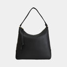 Skinnvesken Tulum Hobo i en klassisk sort grain med gull detaljer på metall deler. Myk hverdagsveske med ekstra stropp for crossbody.