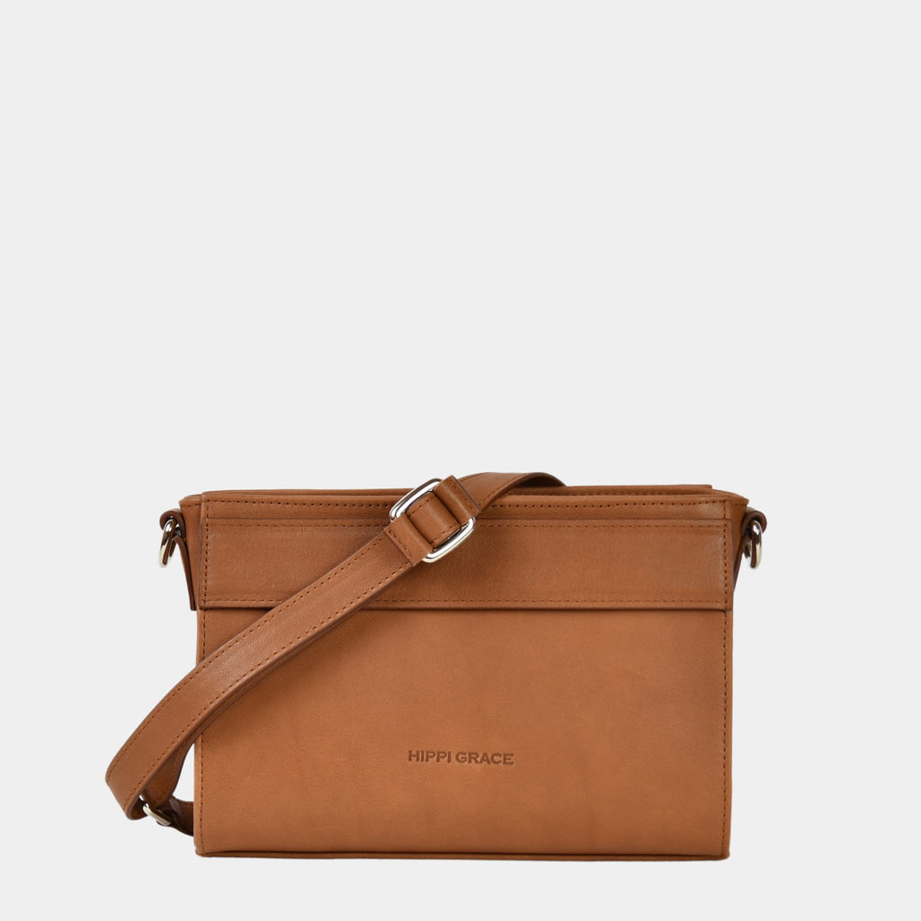 Hippi Grace Kyoto er en liten skinnveske til dame i fargen bohem luxe tan. Vesken kommer med en regulerbar og avtagbar crossbody stropp. Lysebrun crossbody småveske i ku-skinn. Hverdagsveske i ekte skinn. Festveske i ekte skinn. Norsk design. Glidelås lukking i topp. Brun skinnveske. Skinnveske i brun. Brun veske i ekte skinn. Crossbody veske i ekte skinn. 