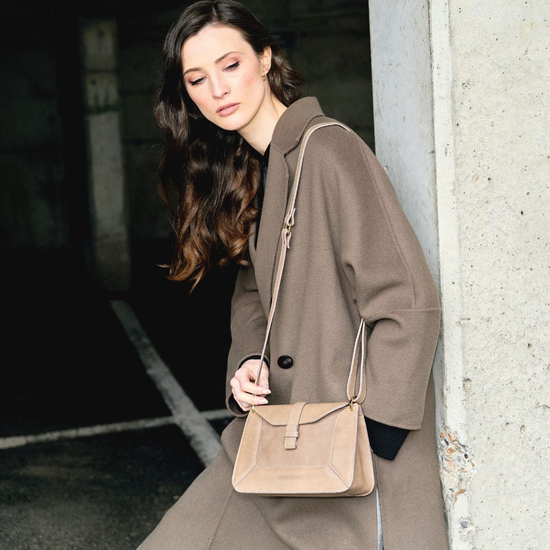 Hippi Grace Lille Roma i fargen bohem luxe beige er en liten skinnveske til dame. Vesken kommer med en lang crossbody stropp, som er regulerbar og avtagbar. Vesken har nydelige detaljer, og gullfarget metall. Crossbody vesken har et praktisk interiør med flere lommer, og lukkes med en magnetknapp i front. Norsk design. Vesken er perfekt til både reise og fest. Beige liten skinnveske dame. Beige liten veske i skinn. Bilde av vesken på en modell. [wv]