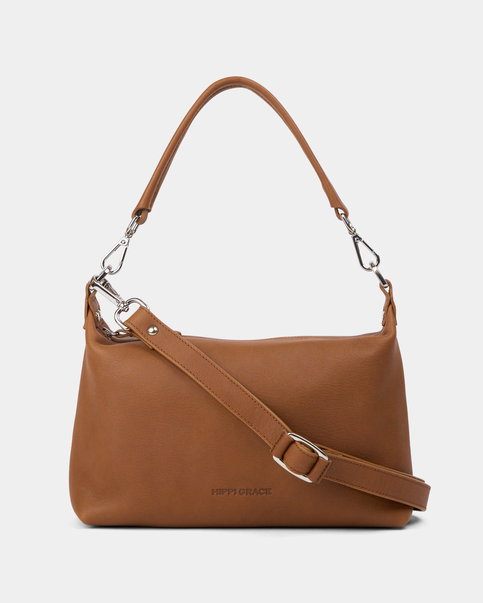 Hippi Grace Lucca i fargen bohem luxe tan er en liten skinnveske til dame. Vesken har et minimalistisk og tidløst design, og har et praktisk interiør med glidelås lukking i topp. Skinnvesken kommer med en skulderstropp og en regulerbar crossbody stropp, begge avtagnbare. Norsk Design. Lysebrun skinnveske dame. Brun Veske dame. Hverdagsveske. Festveske. Ekte skinn. Bærekraftig. Skulderveske dame. Crossbody veske dame. Crossbodyveske. Små veske. Mindre veske. [wv]