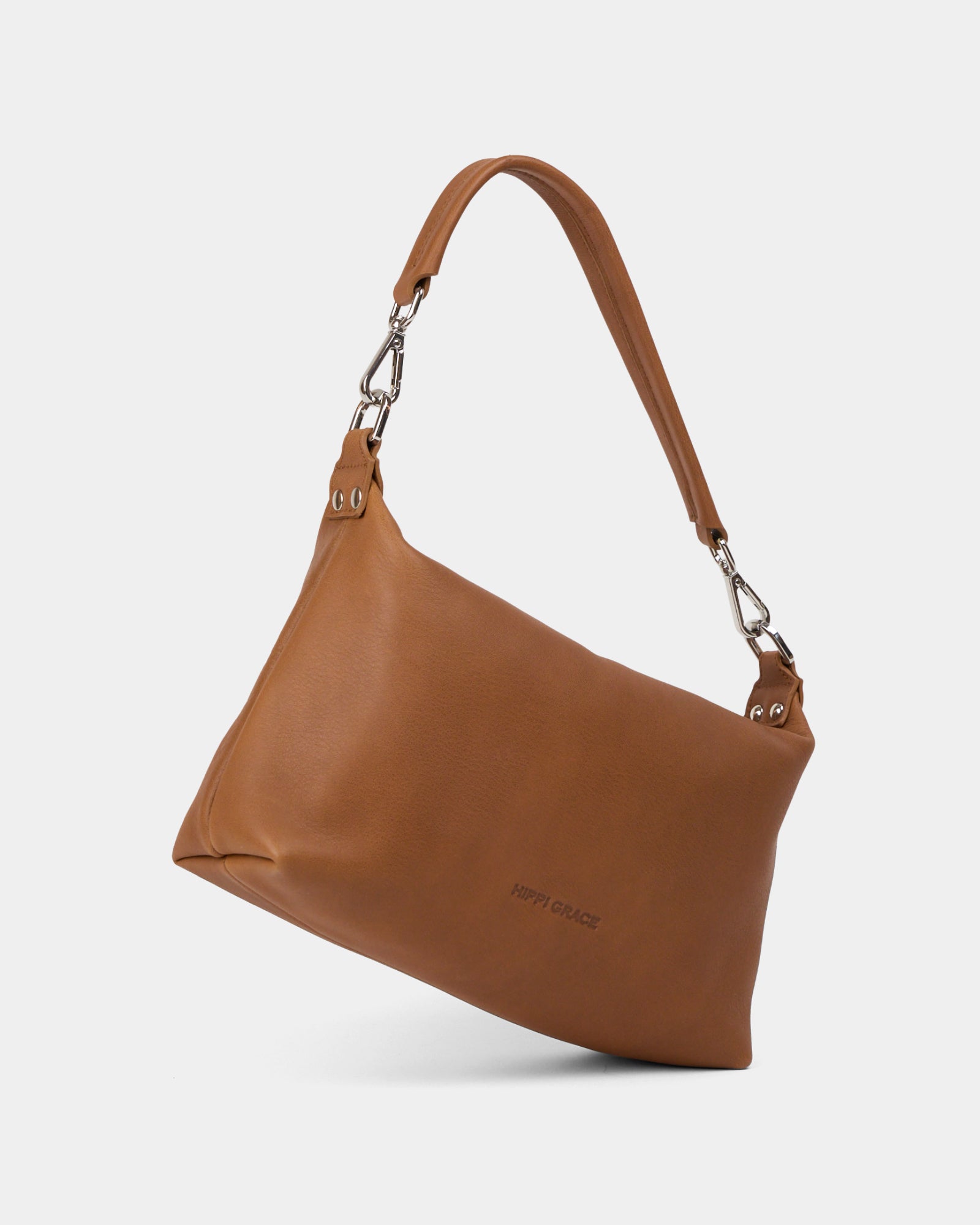 Hippi Grace Lucca i fargen bohem luxe tan er en liten skinnveske til dame. Vesken har et minimalistisk og tidløst design, og har et praktisk interiør med glidelås lukking i topp. Skinnvesken kommer med en skulderstropp og en regulerbar crossbody stropp, begge avtagnbare. Norsk Design. Lysebrun skinnveske dame. Brun Veske dame. Hverdagsveske. Festveske. Ekte skinn. Bærekraftig. Skulderveske dame. Crossbody veske dame. Crossbodyveske. Små veske. Mindre veske. Bilde av vesken fra siden. [wv]