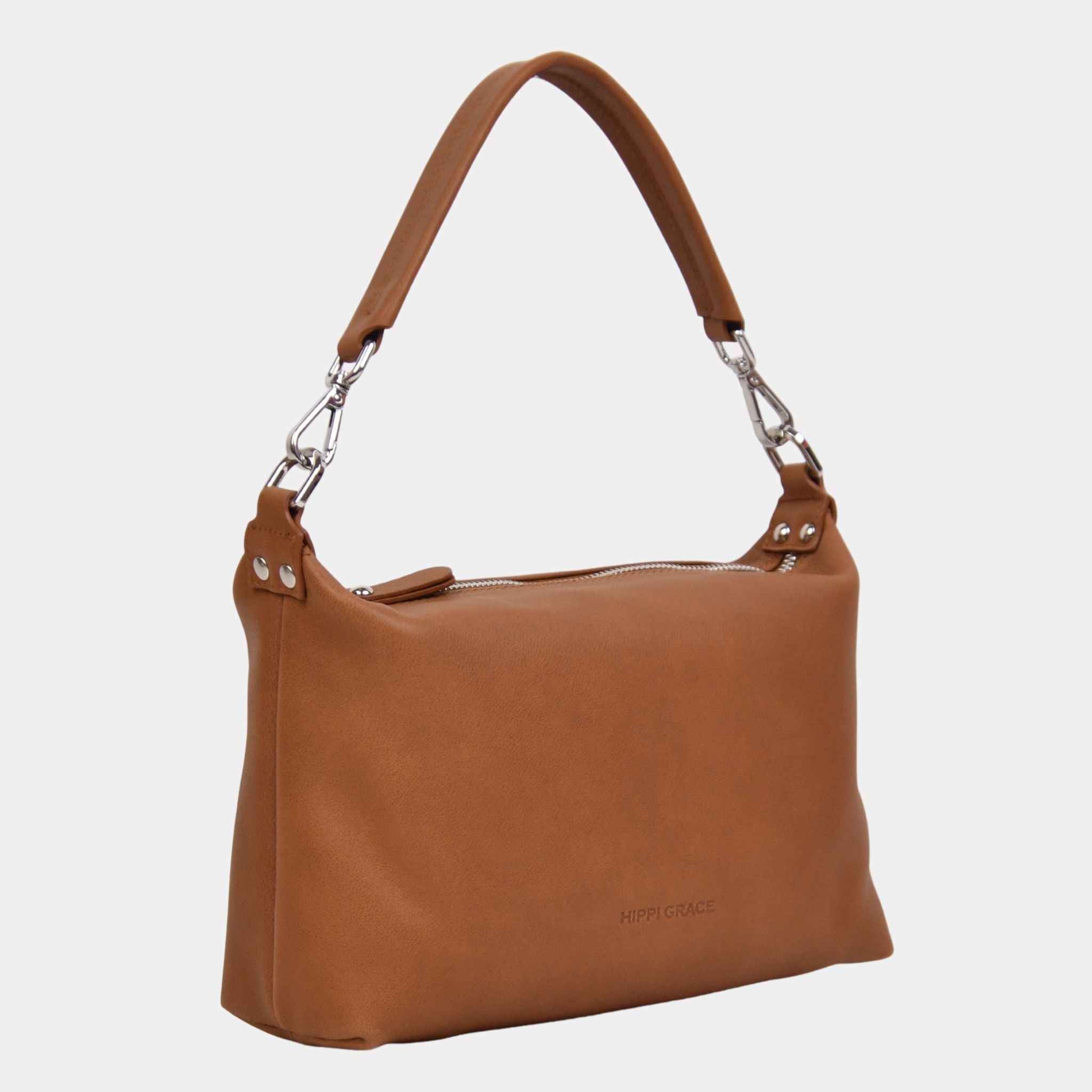 Hippi Grace Lucca i fargen bohem luxe tan er en liten skinnveske til dame. Vesken har et minimalistisk og tidløst design, og har et praktisk interiør med glidelås lukking i topp. Skinnvesken kommer med en skulderstropp og en regulerbar crossbody stropp, begge avtagnbare. Norsk Design. Lysebrun skinnveske dame. Brun Veske dame. Hverdagsveske. Festveske. Ekte skinn. Bærekraftig. Skulderveske dame. Crossbody veske dame. Crossbodyveske. Små veske. Mindre veske. Bilde av vesken fra siden. [wv]