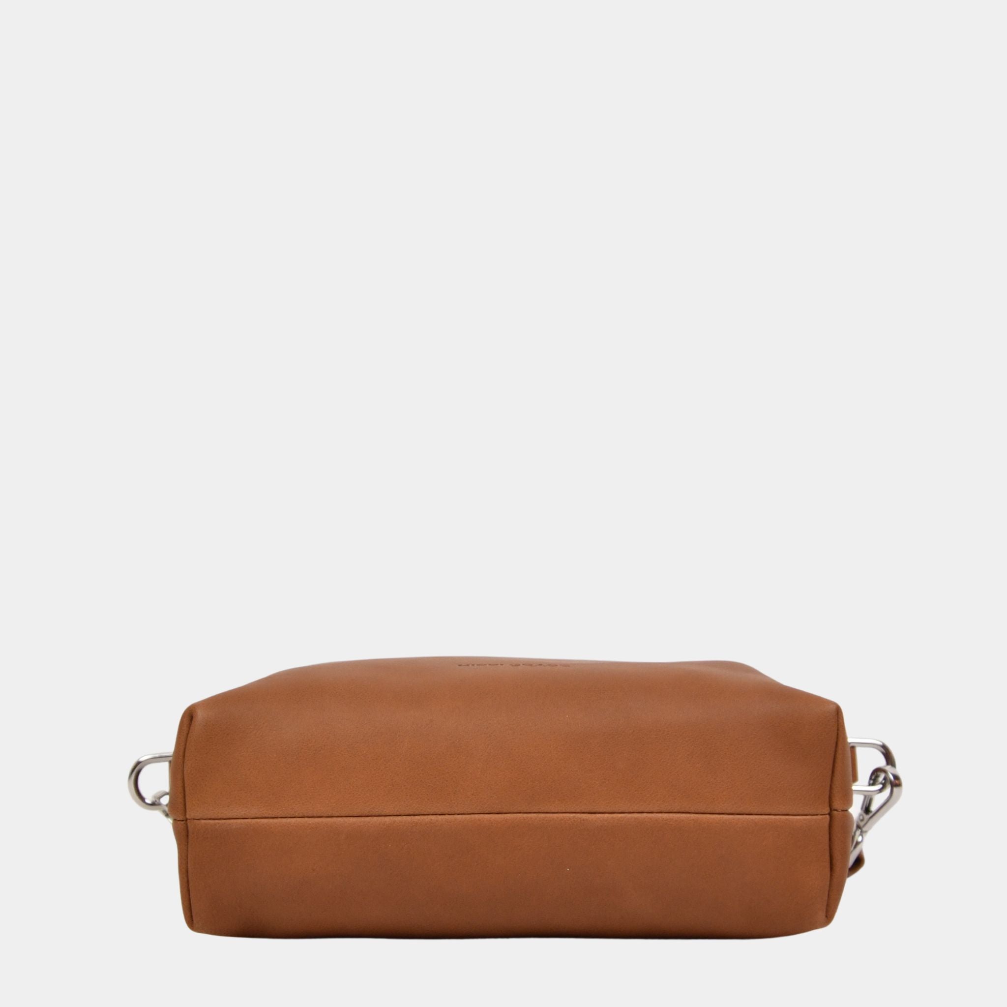 Hippi Grace Lucca i fargen bohem luxe tan er en liten skinnveske til dame. Vesken har et minimalistisk og tidløst design, og har et praktisk interiør med glidelås lukking i topp. Skinnvesken kommer med en skulderstropp og en regulerbar crossbody stropp, begge avtagnbare. Norsk Design. Lysebrun skinnveske dame. Brun Veske dame. Hverdagsveske. Festveske. Ekte skinn. Bærekraftig. Skulderveske dame. Crossbody veske dame. Crossbodyveske. Små veske. Mindre veske. Bilde av undersiden til vesken.  [wv]