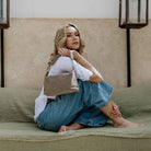 Lucca er den populære damevesken i semsket taupe skinn. Kommer med crossbodystropp og passer godt til hverdagbruk. Avbildet på en modell. [wv]