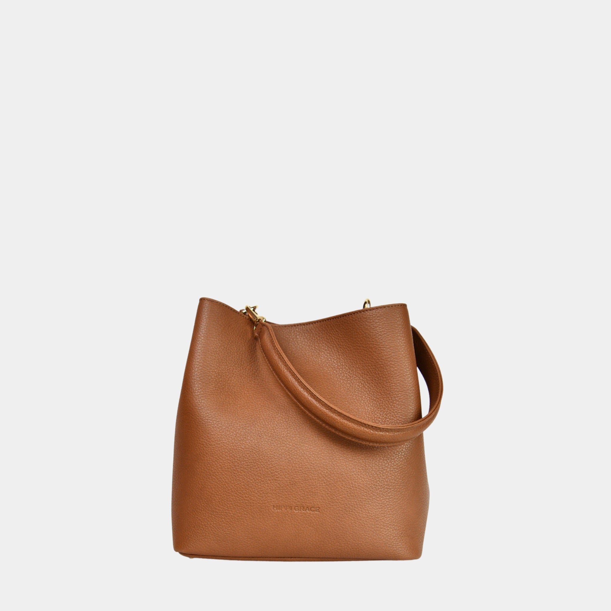 Skulderveske, Ku-skinn, Crossbody Stropp, Magnet lås, glidelås-lomme på framsiden, gulldetaljer. Hippi Grace Marbella i Bohem Luxe Tan med gulldetaljer er en mellomstor skinnveske til dame. Vesken kommer med en skulderstropp og en regulerbar crossbody stropp, begge avtagbare. Vesken har et rent og elegant design, med et praktisk interiør. Veskens interiør har to hovedrom og lfere små lommer, med magnet lukking i topp. Lysebrun skulderveske dame. Lysebrun Crossbody veske. Brun skinnveske. Norsk design.