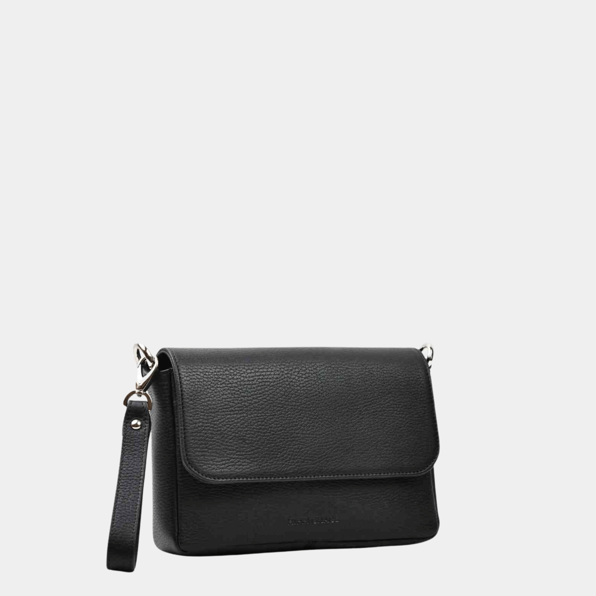 Liten veske, Ku-skinn, magnet-lås, crossbody skulderstropp, sølvdetaljer. Hippi Grace Monte Carlo i fargen klassisk sort er en liten skinnveske til dame. Vesken kommer med en regulerbar crossbody stropp, avtagbar. Vesken har et stilrent og praktisk design, med magnet lås i front. Svart Crossbody veske i ekte skinn. Svart veske dame. Skulderveske svart. Norsk design. Bilde av baksiden til vesken. Bilde av vesken skrått fra forsiden. [wv]