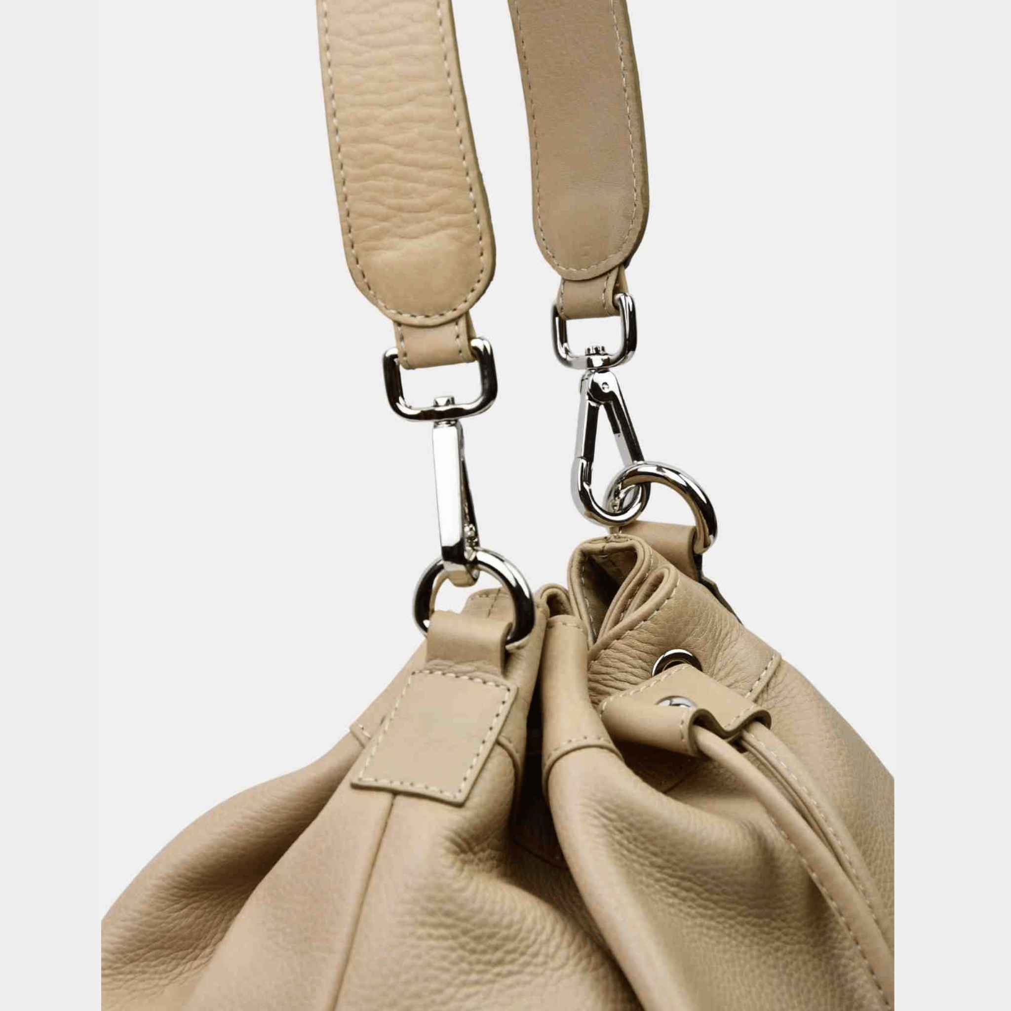 Skulder og Crossbody veske, Klassisk Ku-skinn, Skulder og crossbody stropp, lukkes med snøring, frynse detaljer, glidelås-lomme bak, sølvdetaljer. Hippi Grace Singapore i fargen Bohem Beige er en mellomstor skinnveske til dame. Skinnvesken kommer med en skulderstropp og en regulerbar crossbody stropp, som begge er avtagbare. mellomstor skulderveske dame i ekte skinn. Norsk Design. [wv]