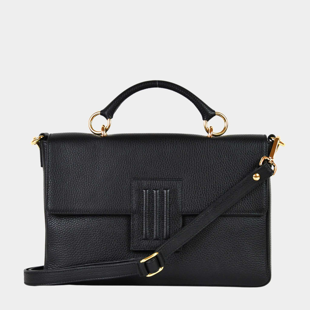 Skinnveske i Svart med Gulldetaljer. Hippi Grace Sotogrande Midi er en mellomstor veske til dame i ekte skinn. Skinnvesken kommer med et elegant håndtak og en avtagbar og regulerbar crossbody stropp. Vesken har et klassisk, funksjonelt og tidløst design som overlever alle trender. Skinnvesken har en klipp lås i front for å lukke vesken. Veske dame. Sort veske. Svart veske dame. jobbveske dame. hverdagsveske dame. Norsk design. Crossbody Veske dame. Crossbodyveske dame. Forsiden av vesken med synlig stropp.