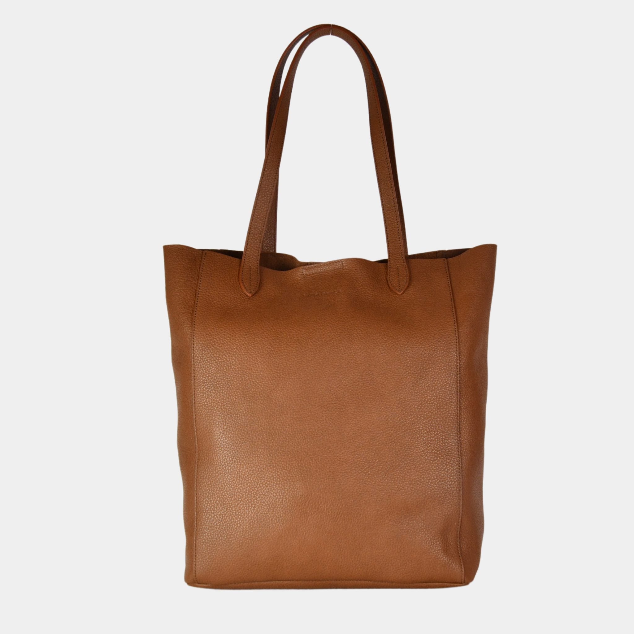 Tote veske i lekkert lyse brunt skinn fra Hippi Grace. Tote vesken Stockholm i fargen bohem luxe tan grain fra Hippi Grace er en stor skinnveske til dame. Skulder vesken passer perfekt som jobbveske, skoleveske, reiseveske og hverdagsveske. Vesken har et stilrent design, med et romslig interiør. Vesken lukkes med en metallknapp i topp. Skinnveske dame. Lysebrun tote bag i ekte skinn. Lysebrun skulderveske i ekte skinn. Norsk design. 