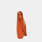 Crossbody veske, Klassisk Ku-skinn, Skulder og crossbody stropp, gulldetaljer. Hippi Grace Tokyo i fargen superior orange er en stor skinnveske til dame. Vesken kommer med en regulerbar crossbody stropp som også er avtagbar. Crossbody vesken har et lekkert design med en gullås i front. Skuldervesken har et praktisk interiør, og passer perfekt som Jobbveske, skoleveske, hverdagsveske og reiseveske. Norsk design. Oransje skinnveske dame. Jobbveske i ekte skinn. Bilde av siden til vesken. [wv]