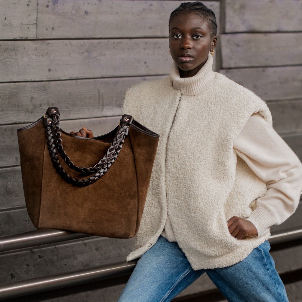 Hippi Grace Bergen New Suede i fargen Mørk Brun med gull . Stor veske til dame i ekte skinn. Stor skinnveske til dame. Stor skulderveske til dame. Jobbveske dame i mørk brun. Skinnveske i mørk brun. Brun jobbveske til dame. Vesken har flettede skulderstropper med gulldetaljer. Den har et romslig hovedrom med glidelås lukking i topp. bag. veske dame i ekte skinn. norsk design. Semsket Skinn. [wv]