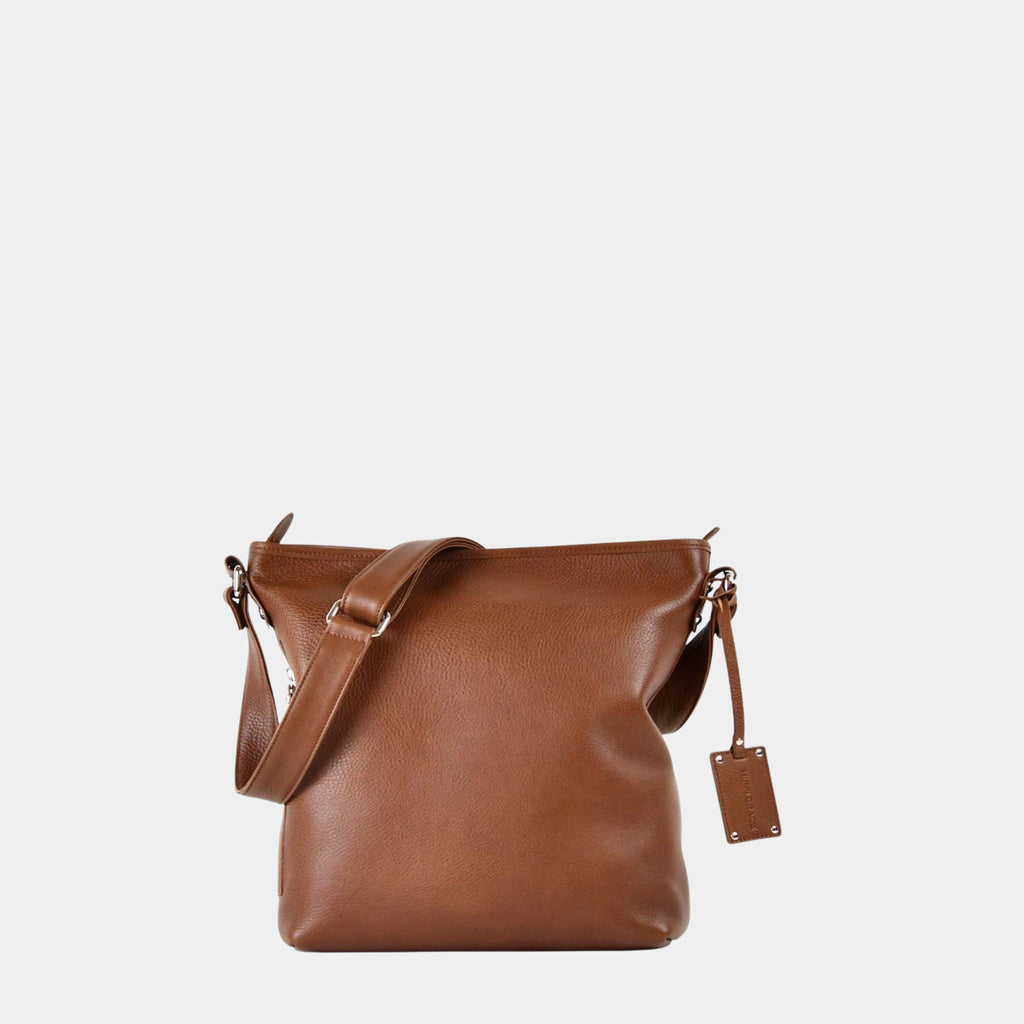 Hippi Grace Lille Amsterdam er en mellomstor skinnveske til dame i fargen Bohem Luxe Tan Grain. Crossbody veske, Klassisk Ku-skinn, regulerbar skulderstropp, glidelås-lukning, sølvdetaljer. Skulderveske i ekte skinn. Crossbody veske. Jobbveske. Hverdagsveske. Skoleveske. Reiseveske. Norsk design. Lysebrun skinnveske. Lysebrun veske. Lysebrun crossbody veske i ekte skinn.