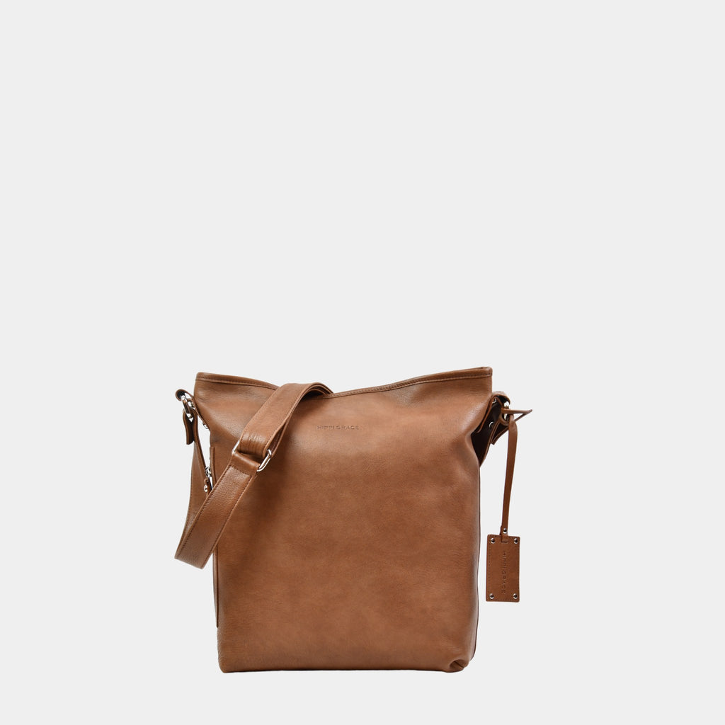 Hippi Grace Lille Amsterdam er en mellomstor skinnveske til dame i fargen Bohem Luxe Tan. Crossbody veske, Klassisk Ku-skinn, regulerbar skulderstropp, glidelås-lukning, sølvdetaljer. Skulderveske i ekte skinn. Crossbody veske. Jobbveske. Hverdagsveske. Skoleveske. Reiseveske. Norsk design. Lysebrun skinnveske. Lysebrun veske. Lysebrun crossbody veske i ekte skinn.