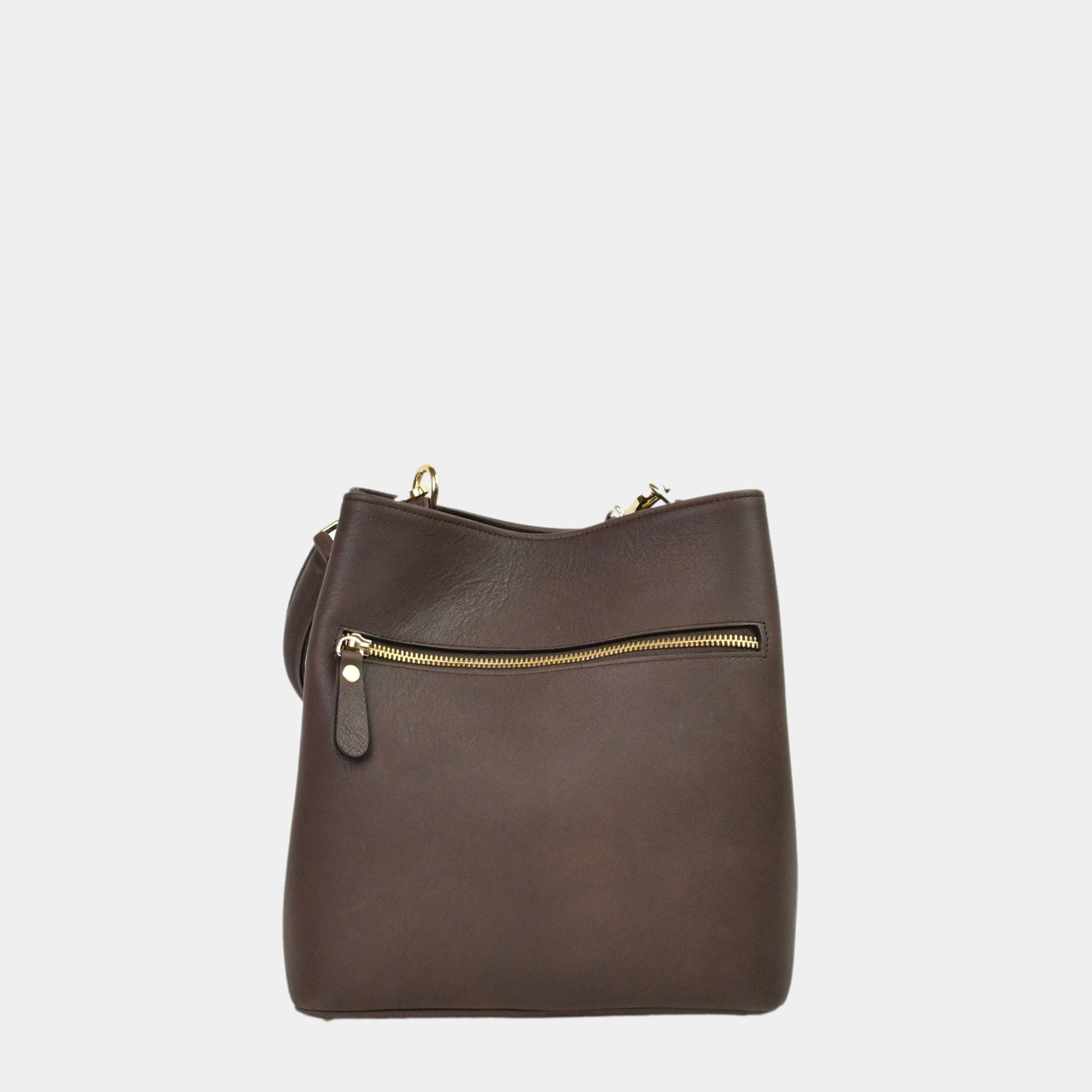 Hippi Grace Marbella i Bohem Luxe Mocca med Gulldetaljer er en mellomstor skinnveske til dame. Vesken kommer med en skulderstropp og en regulerbar crossbody stropp, begge avtagbare. Vesken har et rent og elegant design, med et praktisk interiør. Veskens interiør har to hovedrom og flere små lommer, med magnet lukking i topp. Mørkebrun skulderveske dame. Mørkebrun Crossbody veske. Brun skinnveske. Norsk design. Bucket Bag i ekte skinn. Baksiden av vesken. [wv]