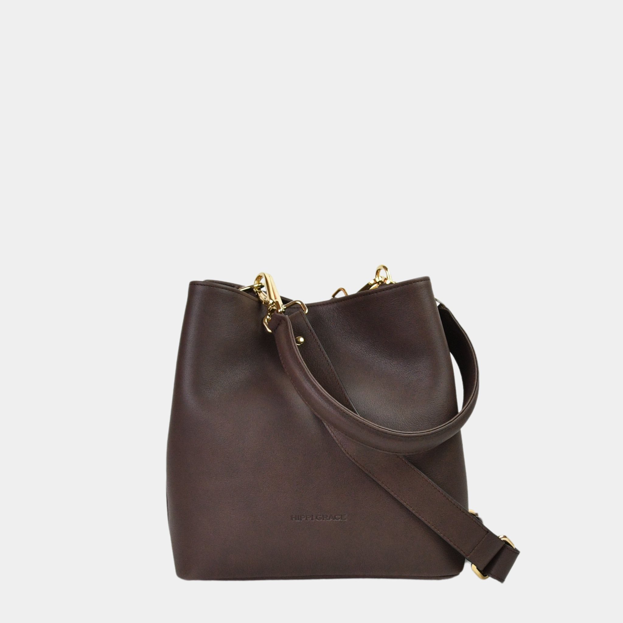 Hippi Grace Marbella i Bohem Luxe Mocca med Gulldetaljer er en mellomstor skinnveske til dame. Vesken kommer med en skulderstropp og en regulerbar crossbody stropp, begge avtagbare. Vesken har et rent og elegant design, med et praktisk interiør. Veskens interiør har to hovedrom og flere små lommer, med magnet lukking i topp. Mørkebrun skulderveske dame. Mørkebrun Crossbody veske. Brun skinnveske. Norsk design. Bucket Bag i ekte skinn. [wv]
