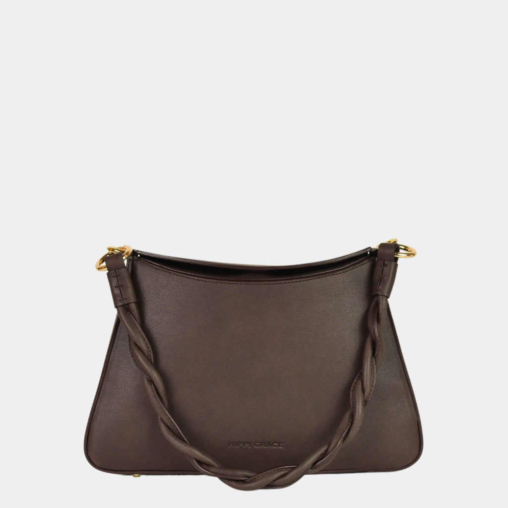 Hippi Grace Paris i fargen bohem luxe Mocca er en liten skinnveske til dame. Vesken kommer med en flettet skulderstropp og en regulerbar crossbody stropp, begge avtagbare. Skuldervesken passer perfekt som både hverdagsveske og festveske. Vesken har en dobbel lukking med magnet knapp i topp. Crossbody vesken har et elegant design, med inspirasjon fra den franske baguette vesken. Norsk design. Mørkebrun Skinnveske dame. Mørkebrun veske i skinn. Festveske dame. Baguette bag i ekte skinn.