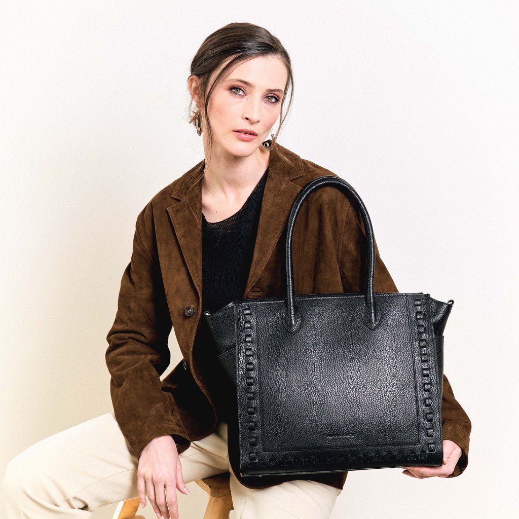 jobbveske, dame i ekte skinn i fargen sort. Hippi Grace Tromsø i fargen klassisk sort er en stor skulderveske til dame i ekte skinn. Vesken har et elegant design og et praktisk interiør, med glidelås lukking i topp. Skinnvesken kommer med skulderstropper og en regulerbar crossbody stropp som er avtagbar. Jobbveske svart. Jobbveske Skinn. Svart skinnveske dame. Svart Skulderveske i ekte skinn. Norsk design. Svart skoleveske dame. Svart reiseveske. Hverdagsveske svart. Bilde av Tromsø med modell.[wv]