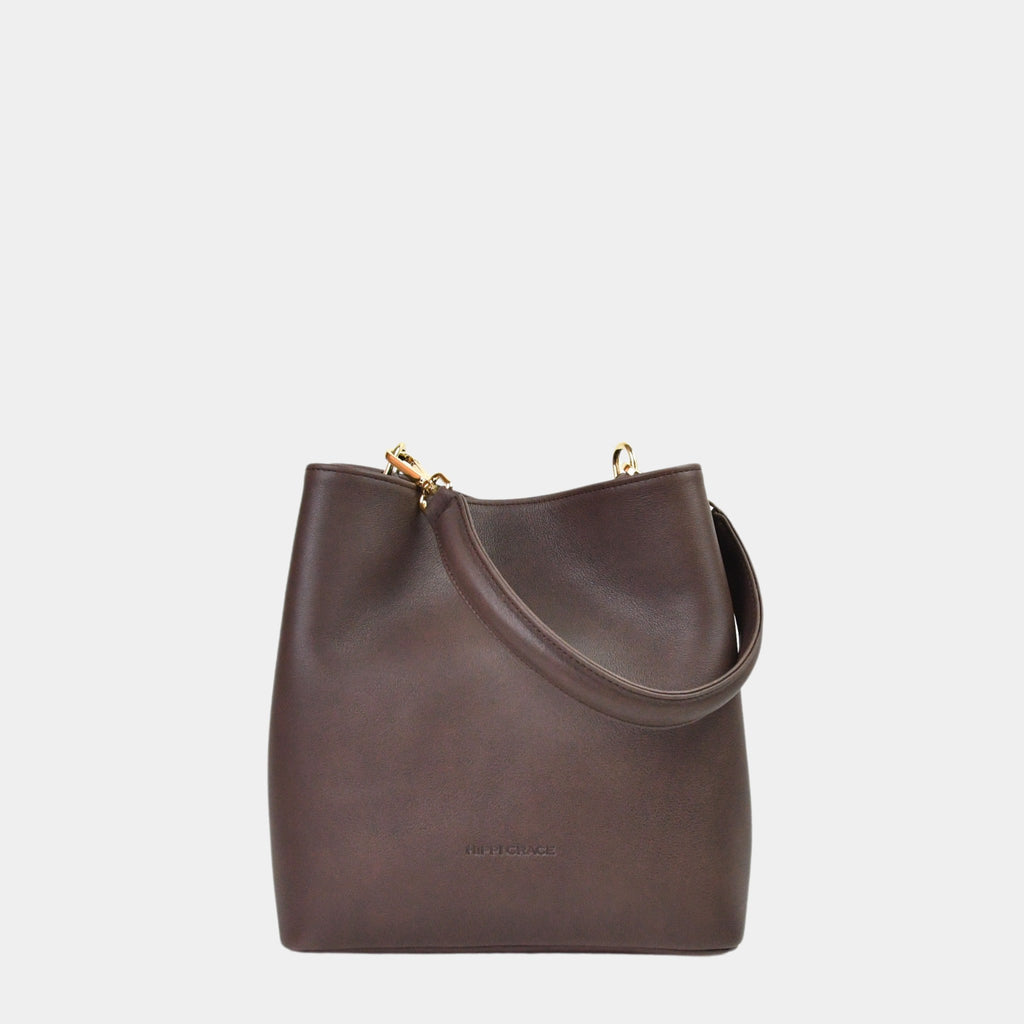 Hippi Grace Marbella i Bohem Luxe Mocca med Gulldetaljer er en mellomstor skinnveske til dame. Vesken kommer med en skulderstropp og en regulerbar crossbody stropp, begge avtagbare. Vesken har et rent og elegant design, med et praktisk interiør. Veskens interiør har to hovedrom og flere små lommer, med magnet lukking i topp. Mørkebrun skulderveske dame. Mørkebrun Crossbody veske. Brun skinnveske. Norsk design. Bucket Bag i ekte skinn. 