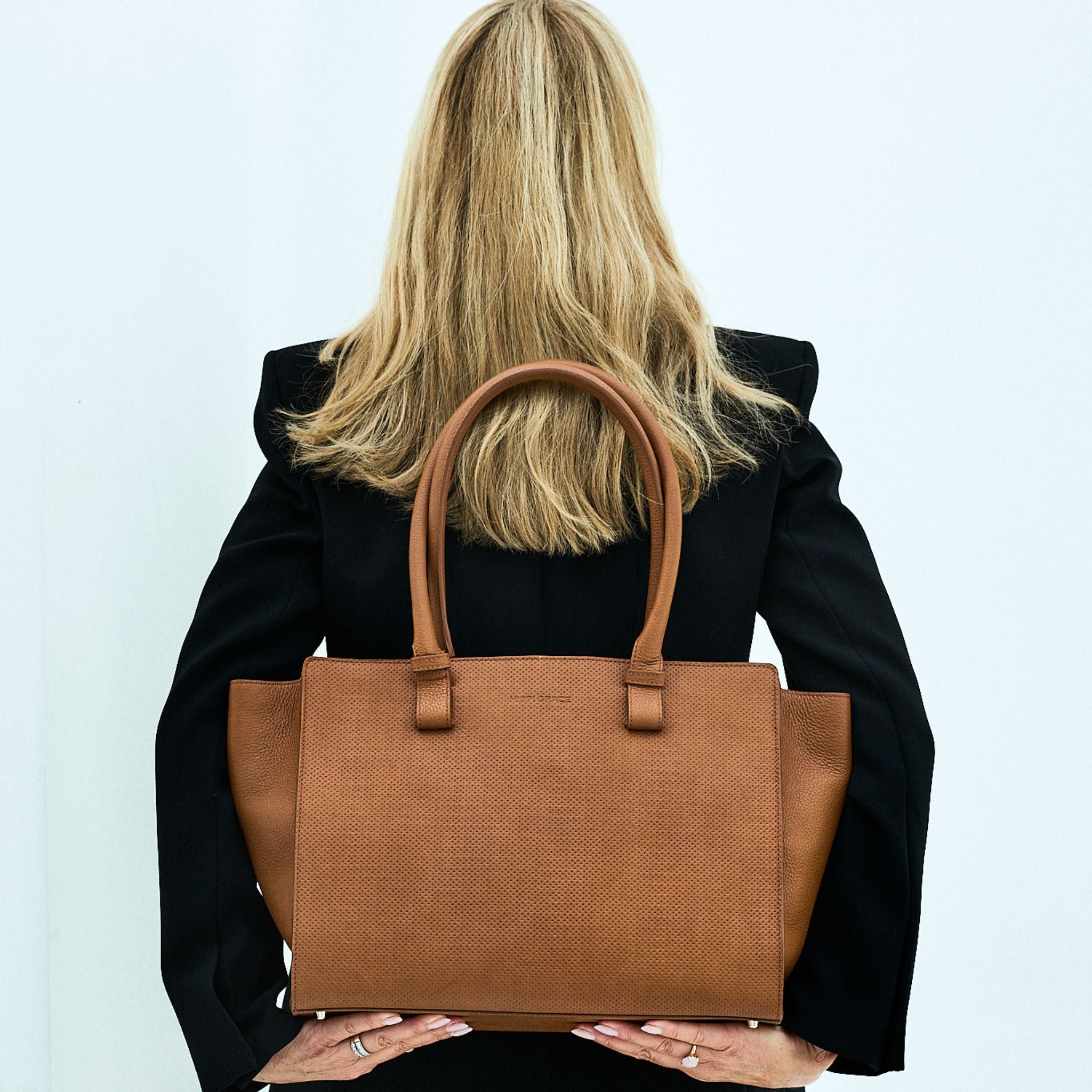 Jobbvesken Berlin fra Hippi Grace i Fargen Bohem Luxe Embossed Tan. Stor veske til dame i ekte skinn. Vesken er en skulderveske, men kommer med en regulerbar crossbody Stropp. Skinnvesken har et romslig interiør med lomme til pc, samt flere mindre lommer. Den har en glidelås lukking i topp. Veske dame. Brun skinnveske. Norsk Design. Her ser du vesken på en modell. [wv]