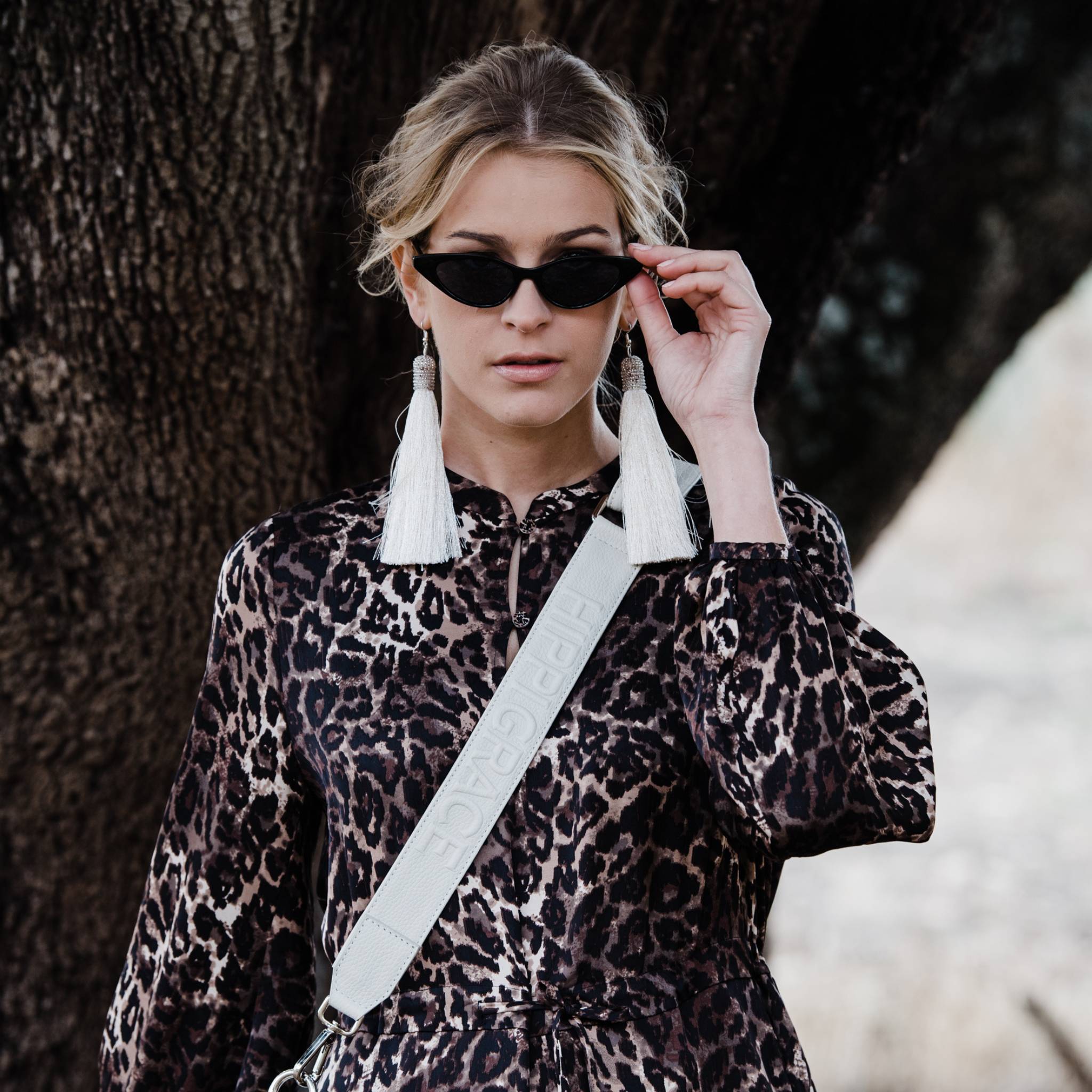 Bred skulderstropp i klassisk Ku-skinn, Crossbody lengde, Preget Logo, sølv detaljer. Hippi Grace Preget Regulerbar Stropp i Klassisk Offwhite. Ekte skinn. Skinnstropp til veske i ekte skinn. Norsk Design. [wv]