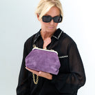 Hippi Grace Positano i fargen Suede Purple m/Gull er en liten skinnveske til dame i Norsk Design. Vesken er laget av nydelig semsket skinn, og har lekre gull detaljer og klikk lås i topp. Selskapsvesken kommer med en lekker metall chain som stropp og en regulerbar Crossbody Stropp, begge avtagbare. . Denne festvesken har et unikt design og et smart interiør. Et smykke til din garderobe. Lilla veske i semsket skinn. Veske i suede. Lilla Suede Veske Dame. Modellbilde av Positano. [wv]