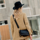 Liten veske, Ku-skinn, magnet-lås, crossbody skulderstropp, sølvdetaljer. Hippi Grace Monte Carlo i fargen coco sort er en liten skinnveske til dame. Vesken kommer med en regulerbar crossbody stropp, avtagbar. Vesken har et stilrent og praktisk design, med magnet lås i front. Svart Crossbody veske i ekte skinn. Svart veske dame. Skulderveske svart. Norsk design. Bilde av vesken på en model. [wv]