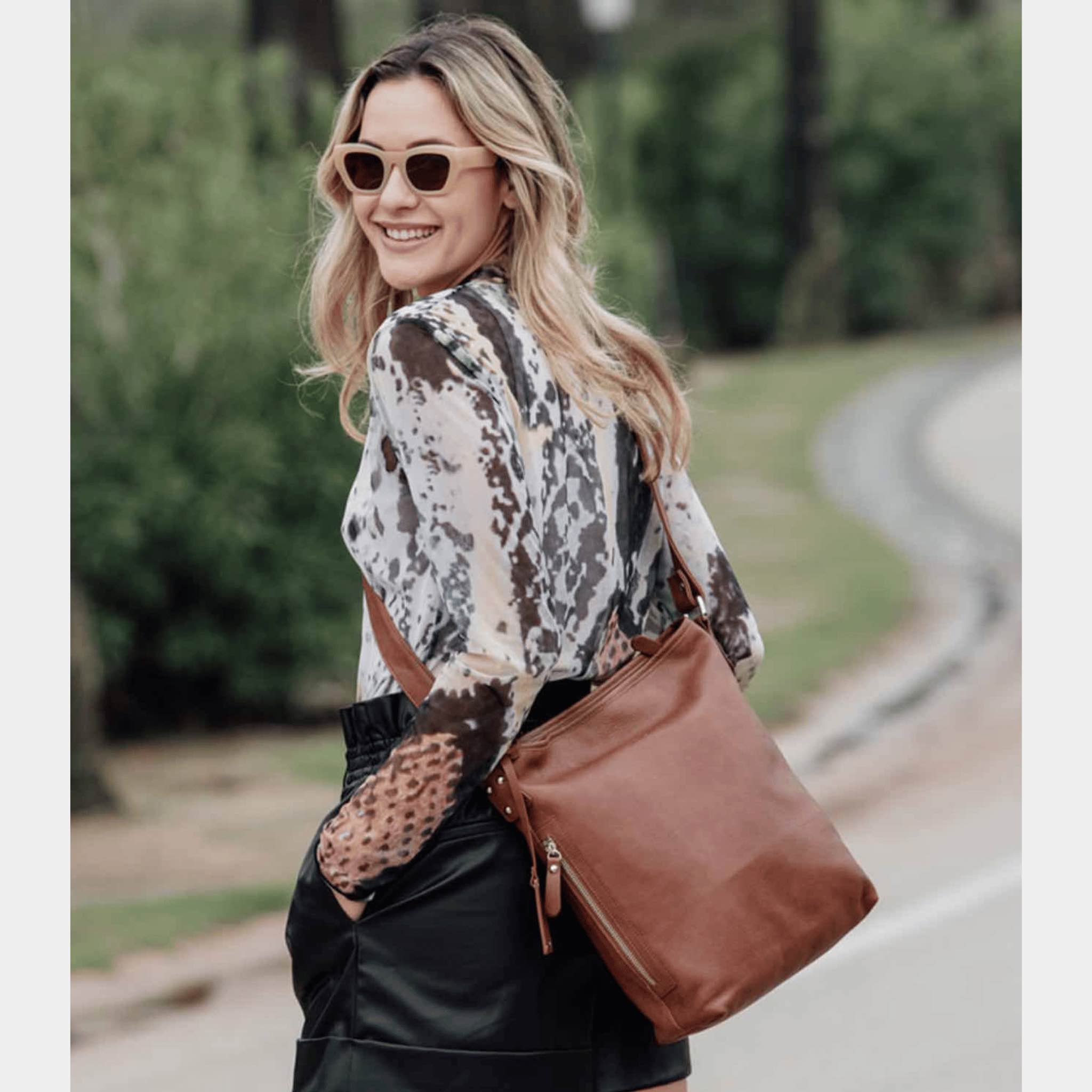 Hippi Grace Lille Amsterdam er en mellomstor skinnveske til dame i fargen Bohem Luxe Tan. Crossbody veske, Klassisk Ku-skinn, regulerbar skulderstropp, glidelås-lukning, sølvdetaljer. Skulderveske i ekte skinn. Crossbody veske. Jobbveske. Hverdagsveske. Skoleveske. Reiseveske. Norsk design. Lysebrun skinnveske. Lysebrun veske. Lysebrun crossbody veske i ekte skinn. [wv]