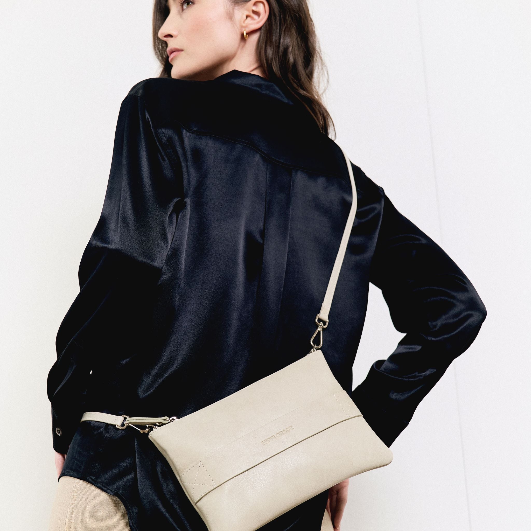 Liten veske i klassisk Ku-skinn med glidelås-lukning, lang skulderstropp og håndleddsstropp. Skinn veske. veske dame. bag. norsk design. lyseblå veske i ekte skinn. Hippi Grace 3in1 i fargen bohem lyseblå. I dette bildet ser du baksiden av vesken.[wv]