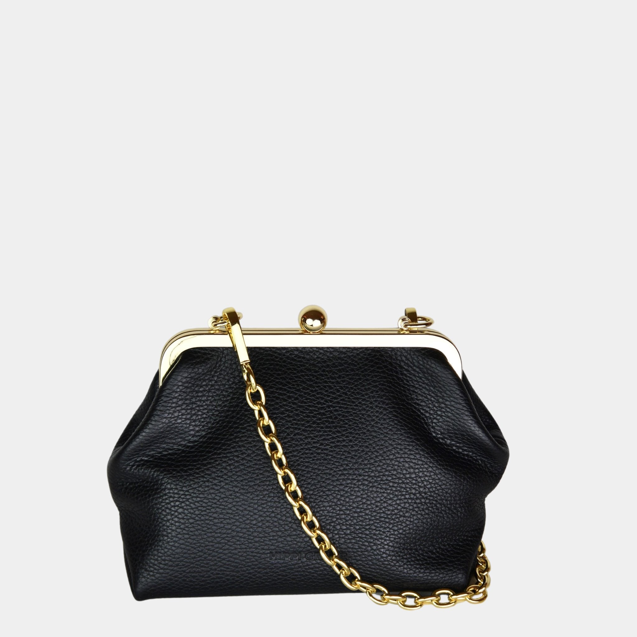Hippi Grace Positano i fargen Klassisk Sort m/Gull er en liten skinnveske til dame i Norsk Design. Vesken er laget av nydelig ekte skinn, og har lekre gull detaljer og klikk lås i topp. Selskapsvesken kommer med en lekker metall chain som stropp og en regulerbar Crossbody Stropp, begge avtagbare. . Denne festvesken har et unikt design og et smart interiør. Et smykke til din garderobe. Svart veske i ekte skinn. Veske i Skinn. Svart Skinnveske Dame. Bilde av forsiden til Positano