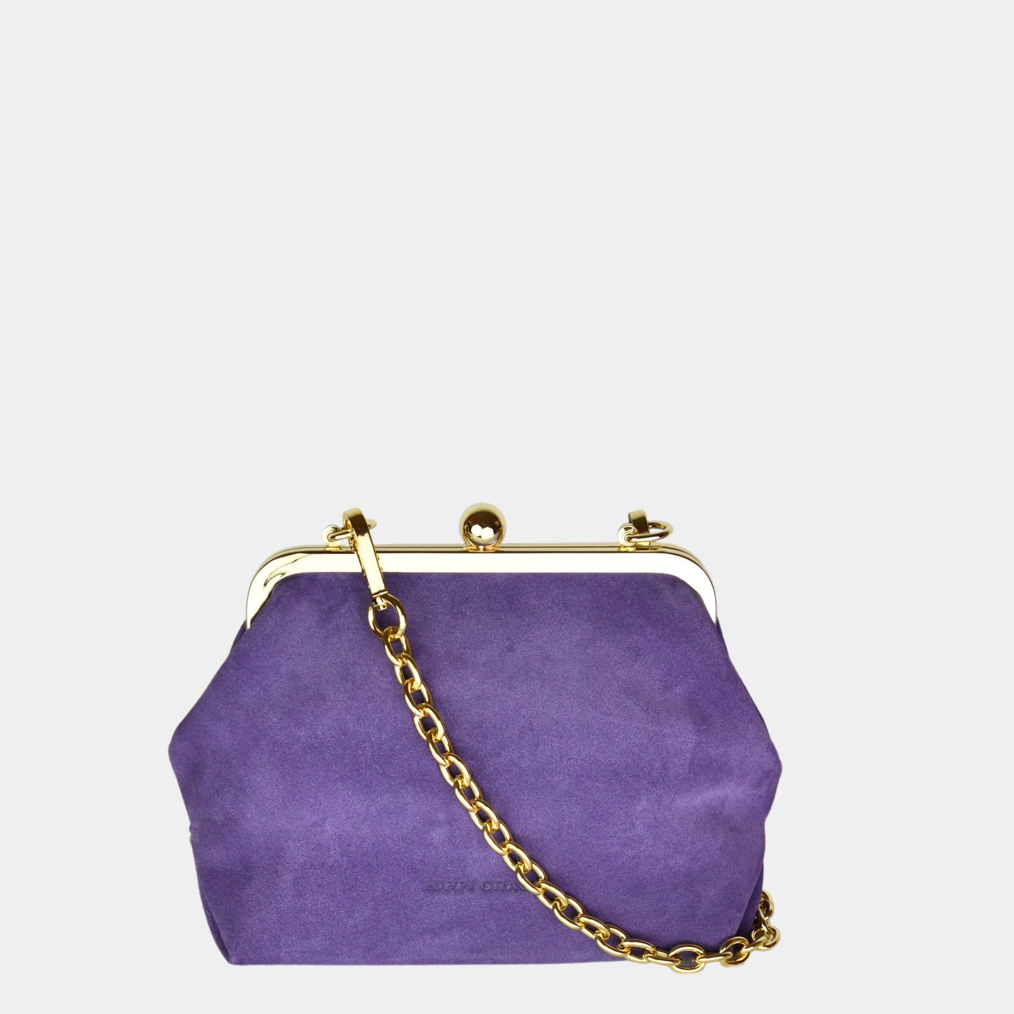 Hippi Grace Positano i fargen Suede Purple m/Gull er en liten skinnveske til dame i Norsk Design. Vesken er laget av nydelig semsket skinn, og har lekre gull detaljer og klikk lås i topp. Selskapsvesken kommer med en lekker metall chain som stropp og en regulerbar Crossbody Stropp, begge avtagbare. . Denne festvesken har et unikt design og et smart interiør. Et smykke til din garderobe. Lilla veske i semsket skinn. Veske i suede. Lilla Suede Veske Dame. Bolde av Forsiden til Positano
